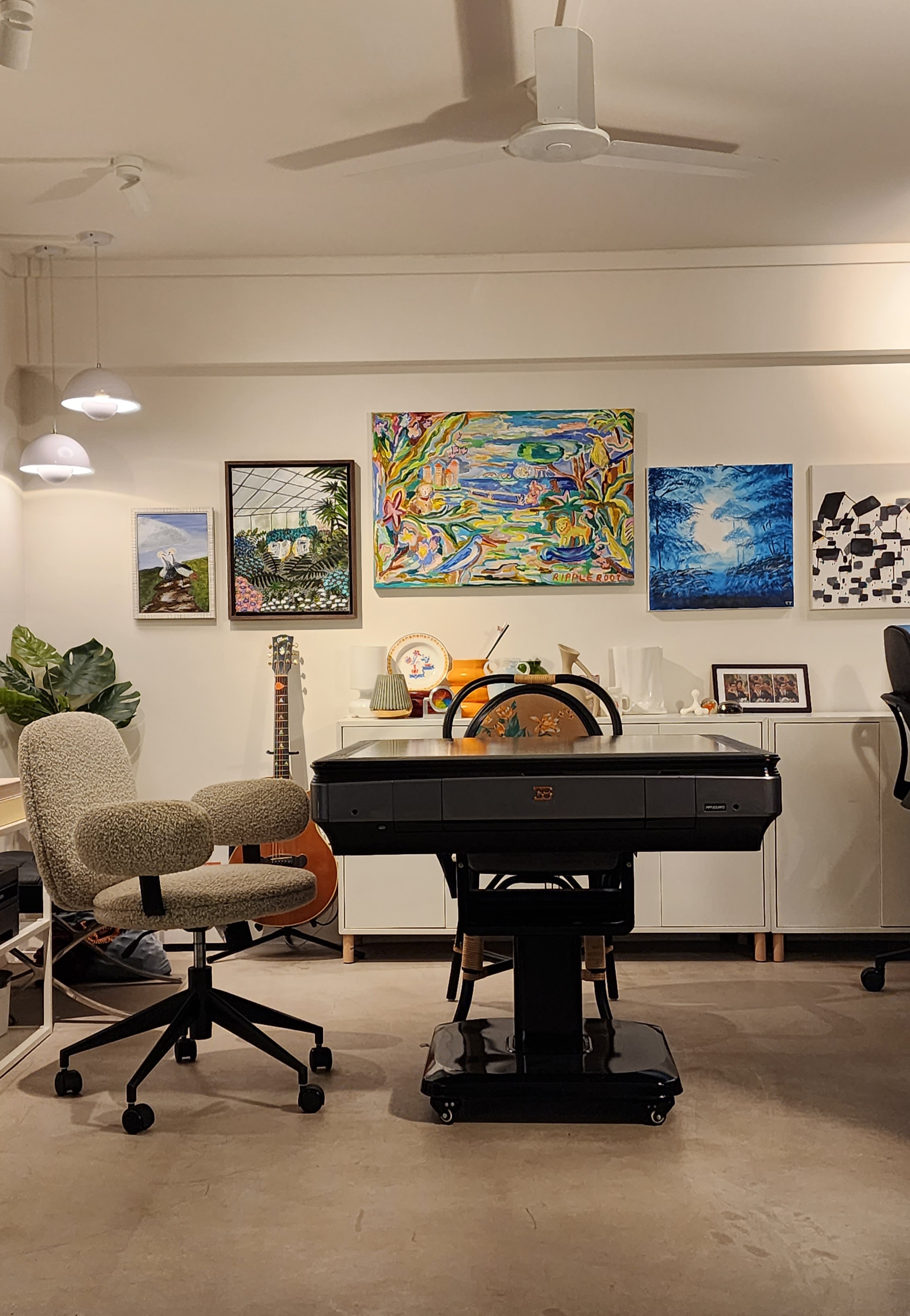 Converting our study into a Mahjong Den - Modern workspace with ergonomic chair, black desk, colorful abstract paintings