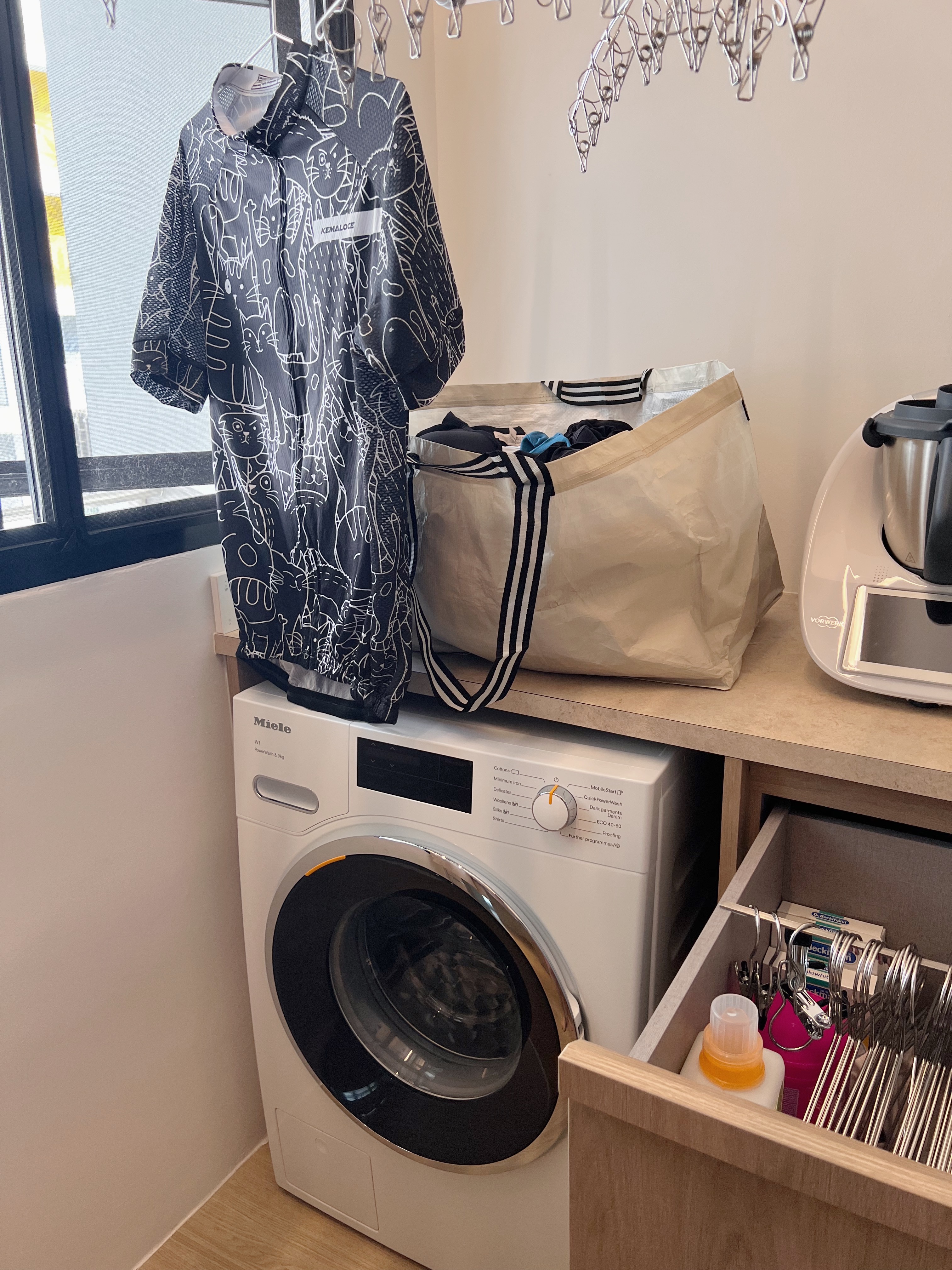 Clean and Fresh: Our Minimalist Laundry Area - Black and white cat pattern shirt, hanging on a drying rack, beige laundry