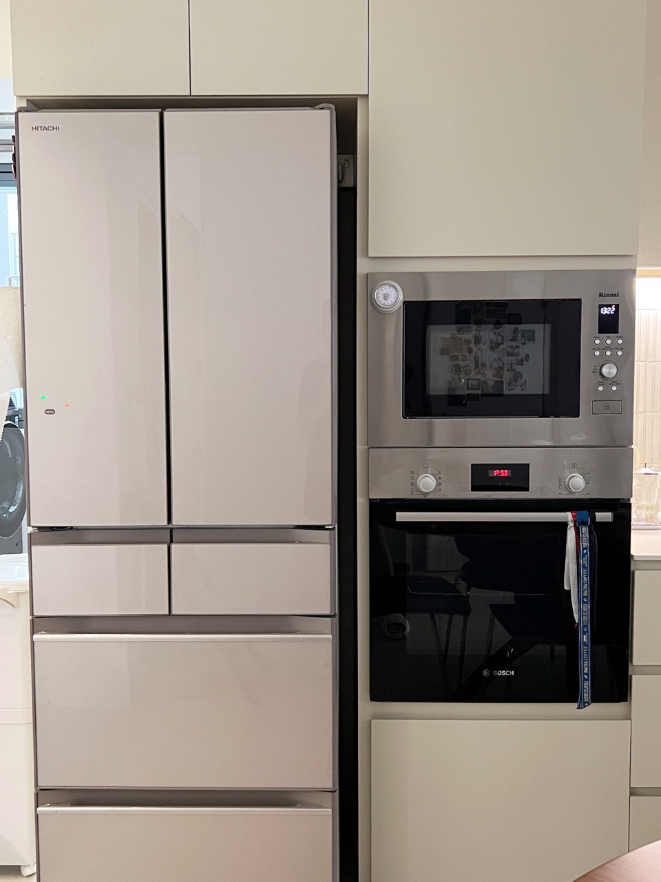 Where the wife spends most of her time at (her love for cooking). - Modern kitchen setup featuring a refrigerator, microwave