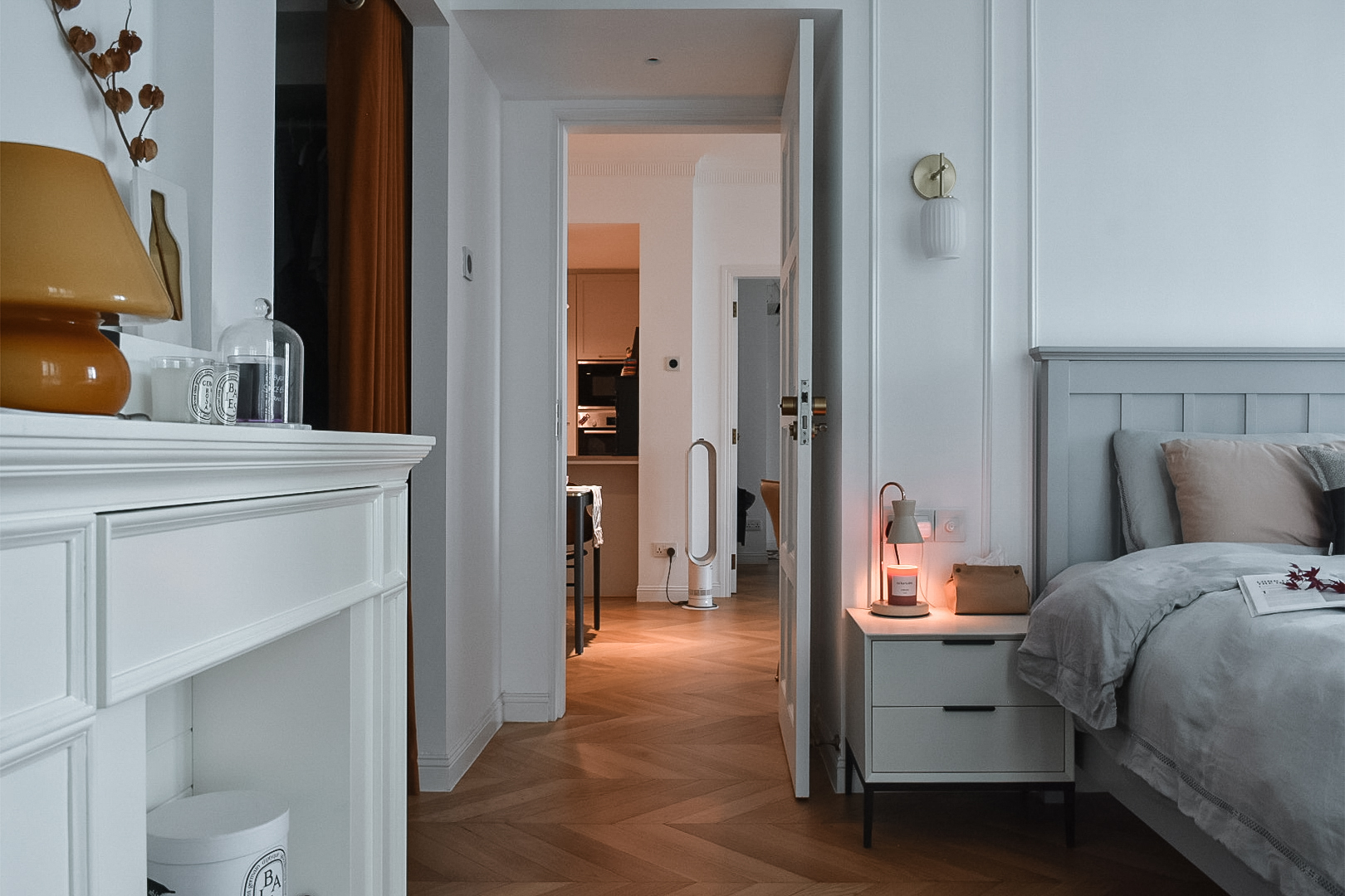 From Ordinary to Extraordinary: Our Master Bedroom Makeover - White vanity with orange lamp, wooden floor, cozy bedroom