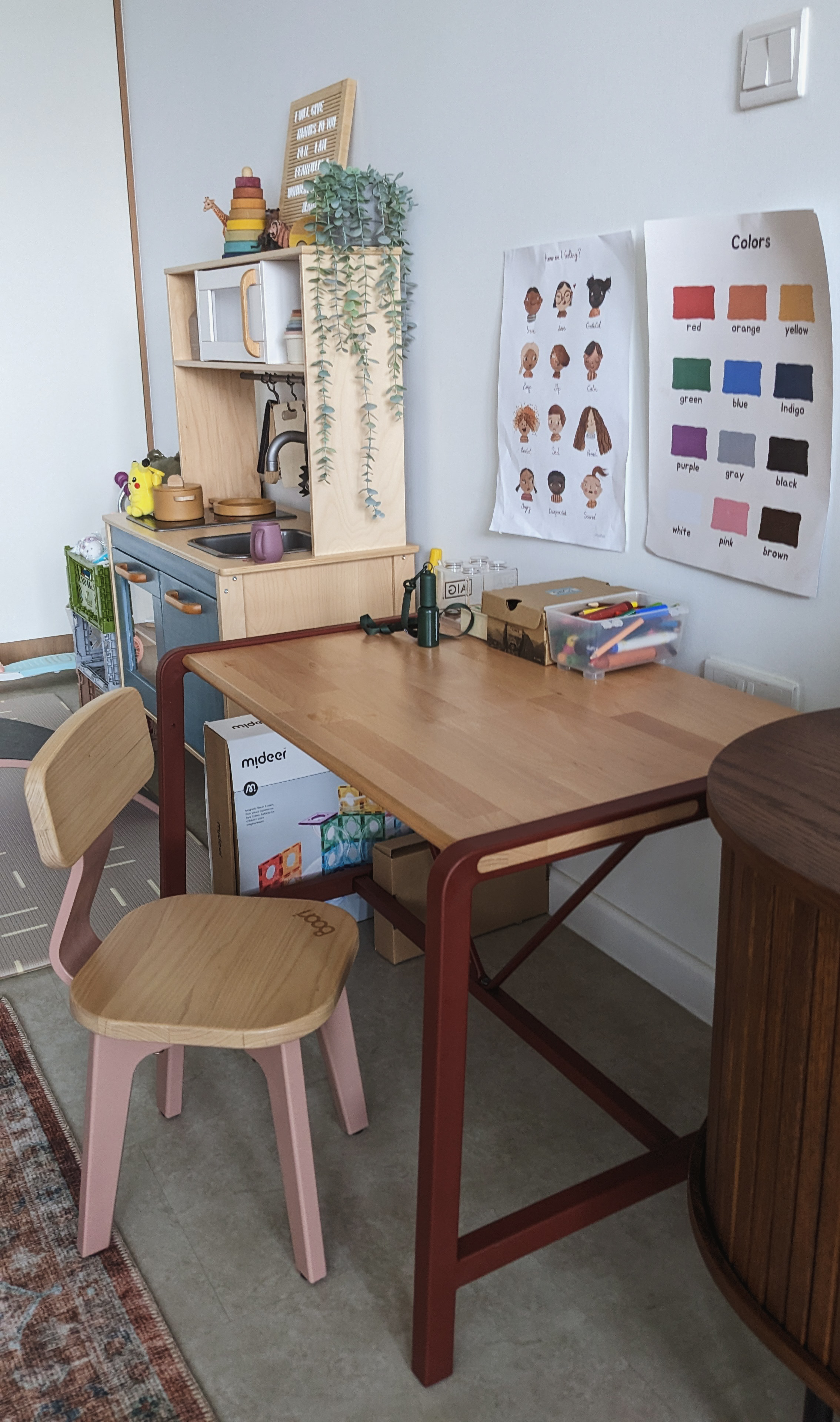 A Canvas for Imagination | Space for play and creativity - Wooden desk with pink chair, colorful children's artwork on wall