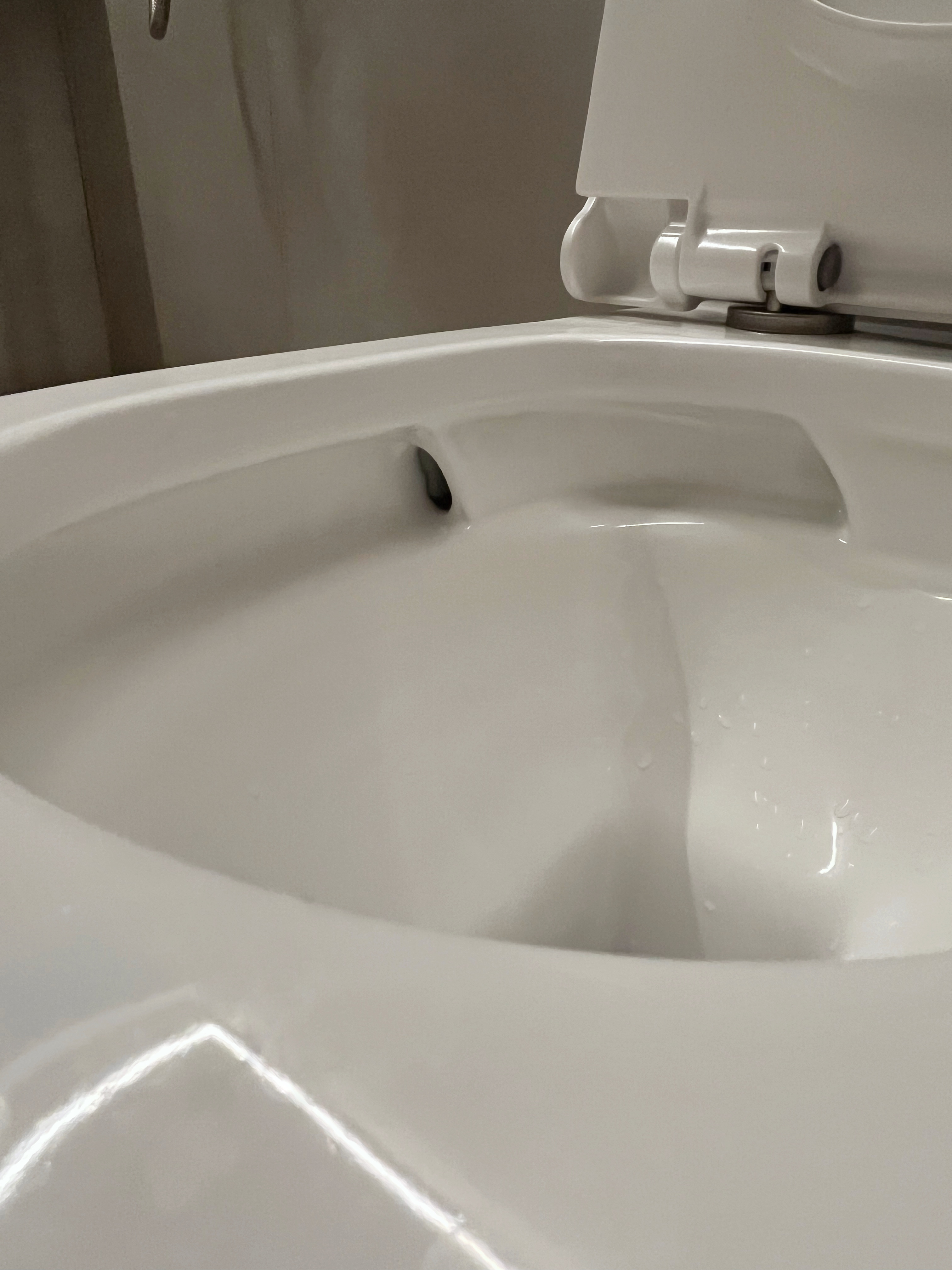 12 Bathroom Renovation Tips We Learned - White toilet bowl, closed lid, smooth surface, glossy finish, modern design, clean