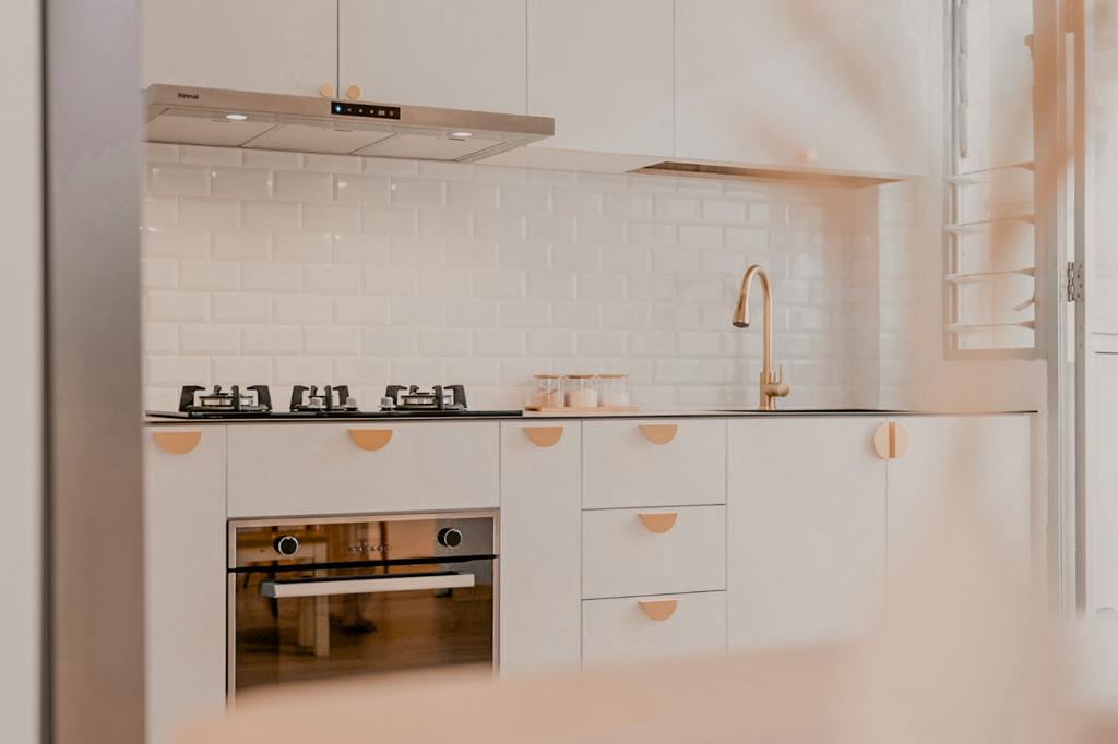 A Simple Kitchen For All Your Possible Needs  - White tiled backsplash, stainless steel range hood, modern oven, built-in