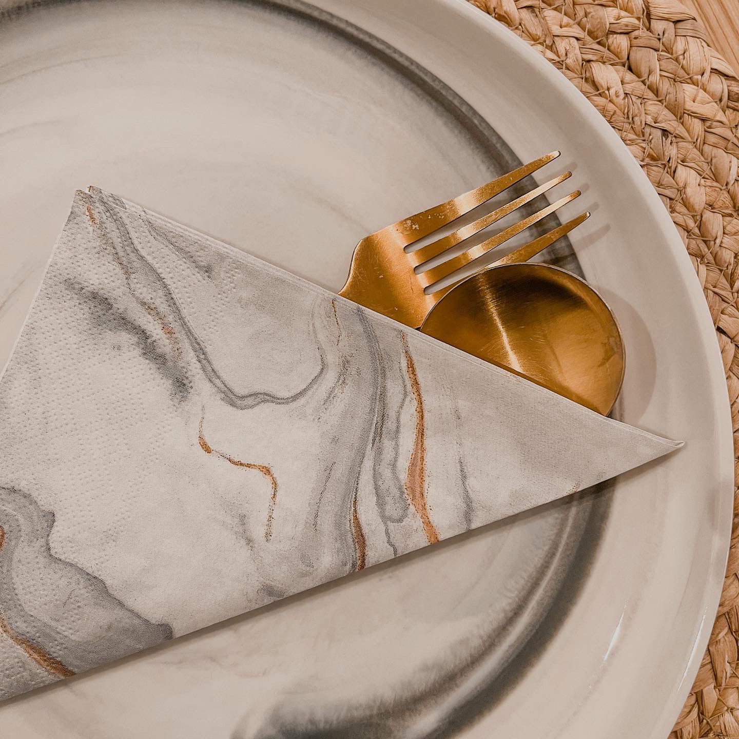 Dining Area with Open Kitchen Concept - White marble plate, gold fork, gold spoon, folded napkin, elegant dining setting