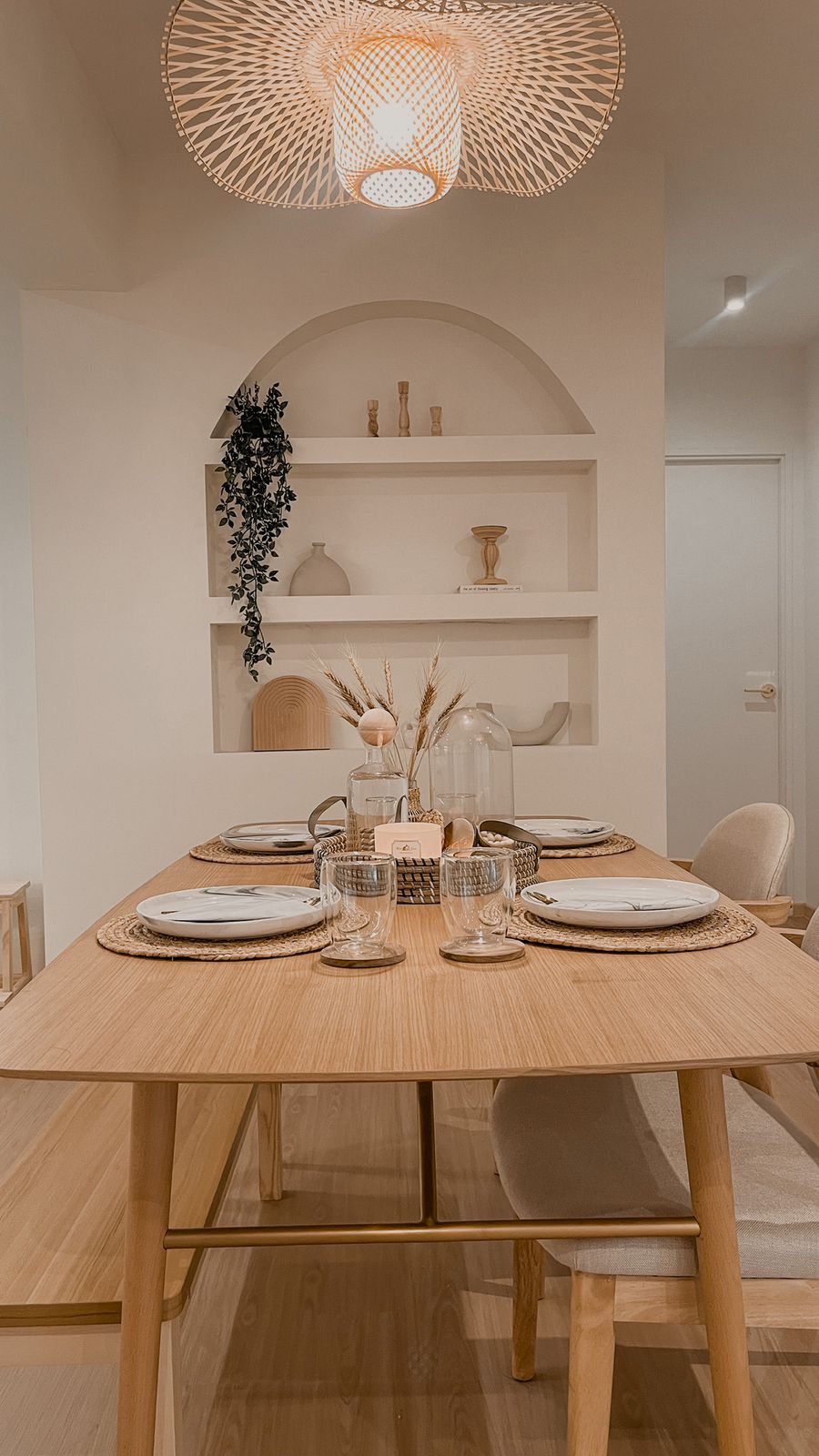 Dining Area with Open Kitchen Concept - Wooden dining table, minimalist decor, natural light, woven placemats, elegant