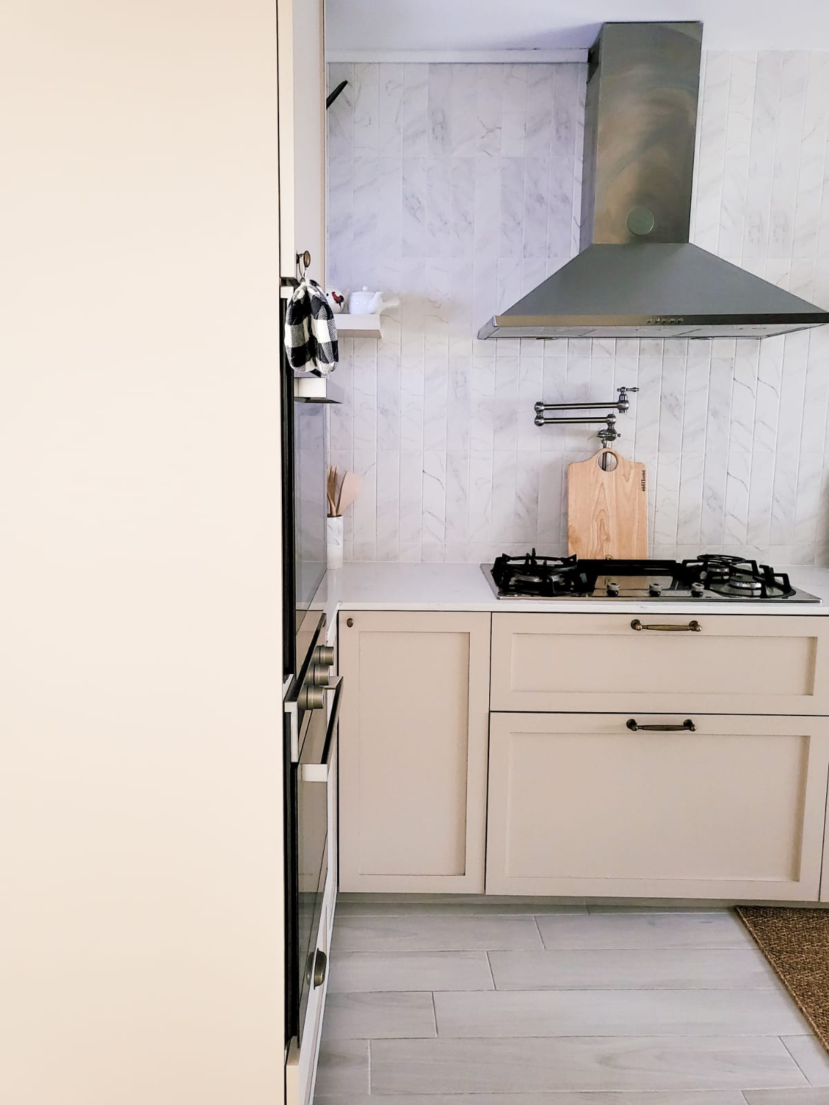 Combining the best of Kitchen Spaces and the English Countryside  - White marble tiles, modern stove, black gas stove, beige