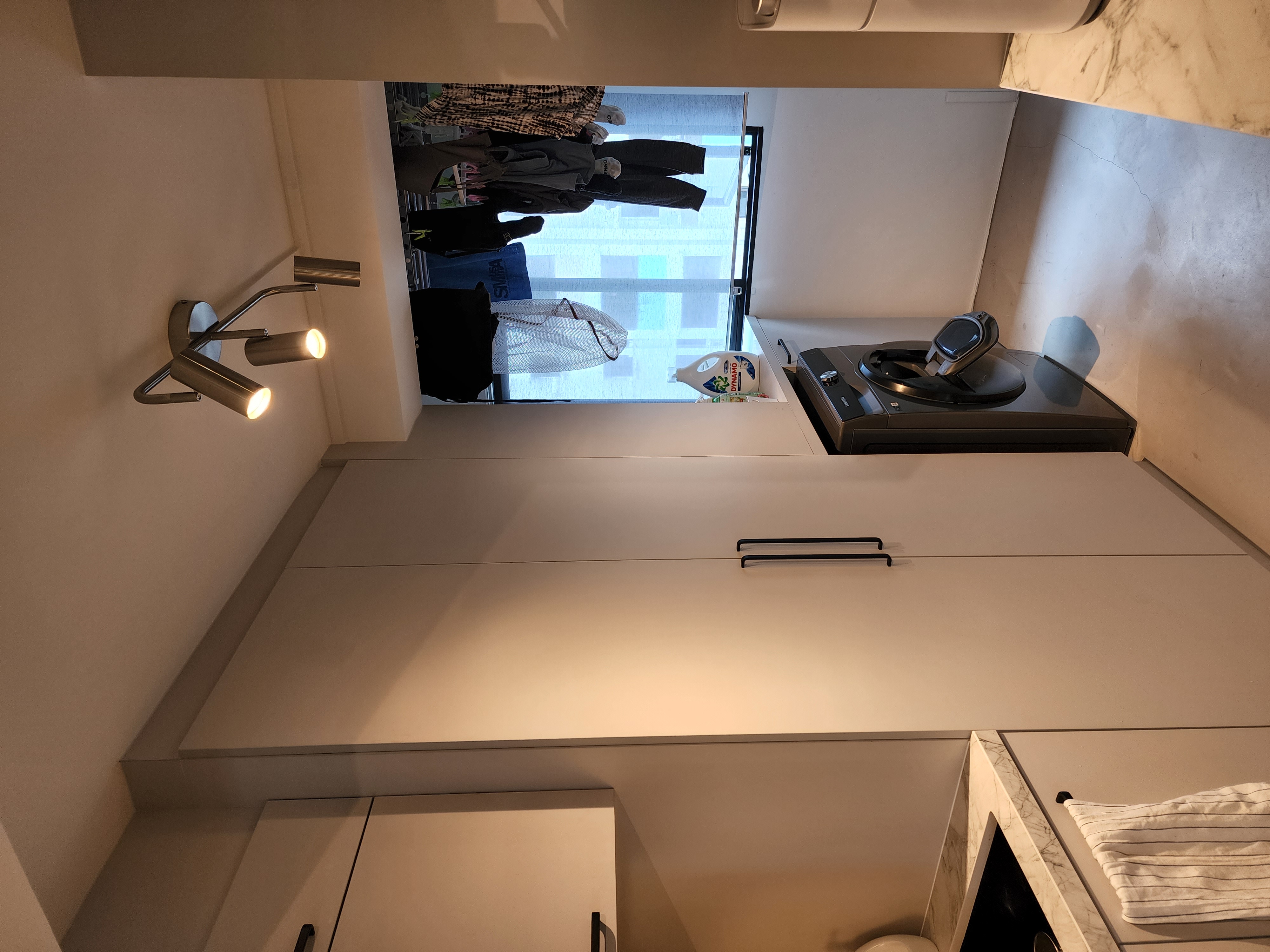 Small but mighty service yard - Modern minimalist kitchen, sleek cabinets, integrated oven, stainless steel appliances