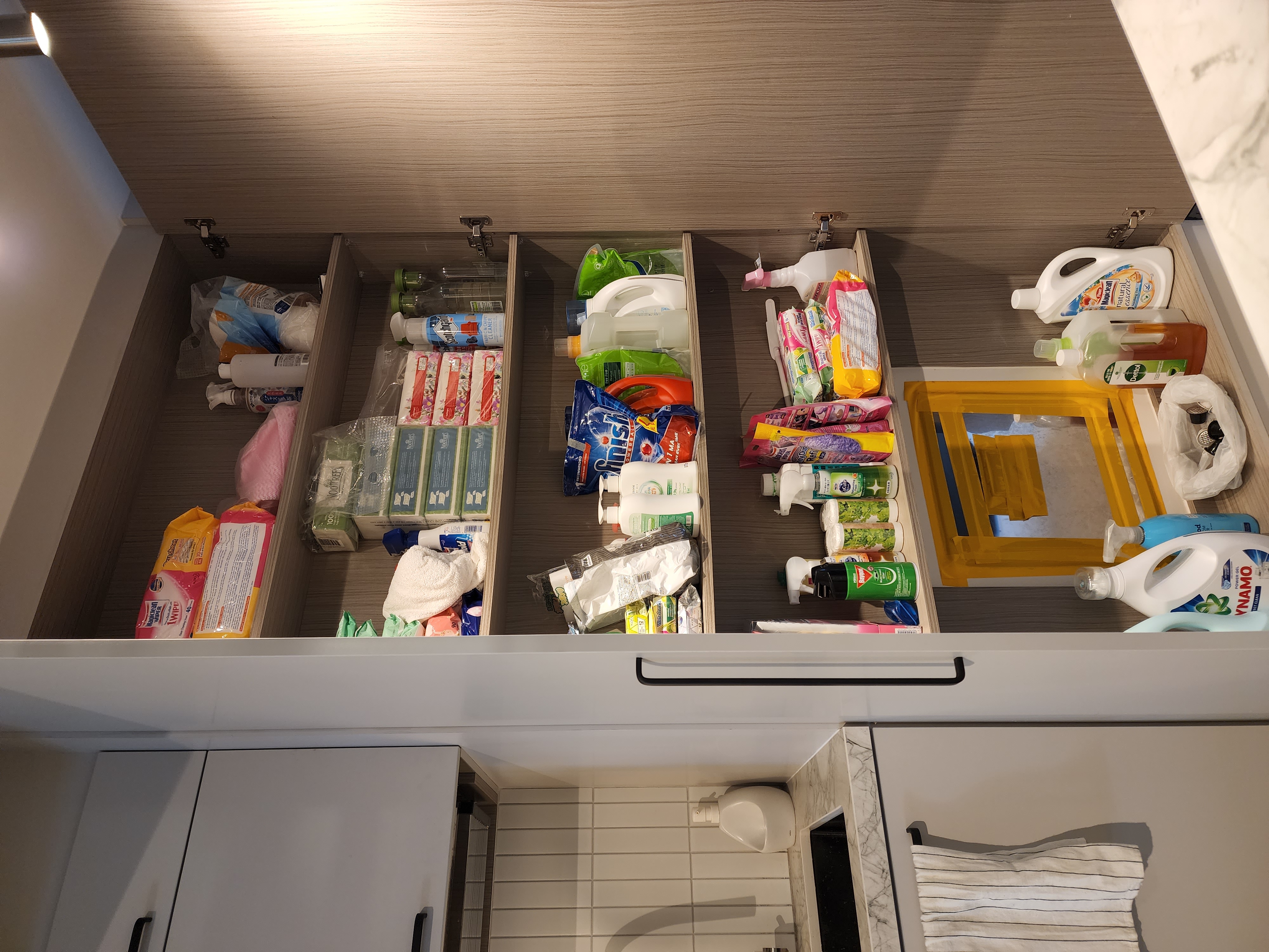 Small but mighty service yard - Bathroom drawer, organized storage, neatly arranged toiletries, various cleaning supplies