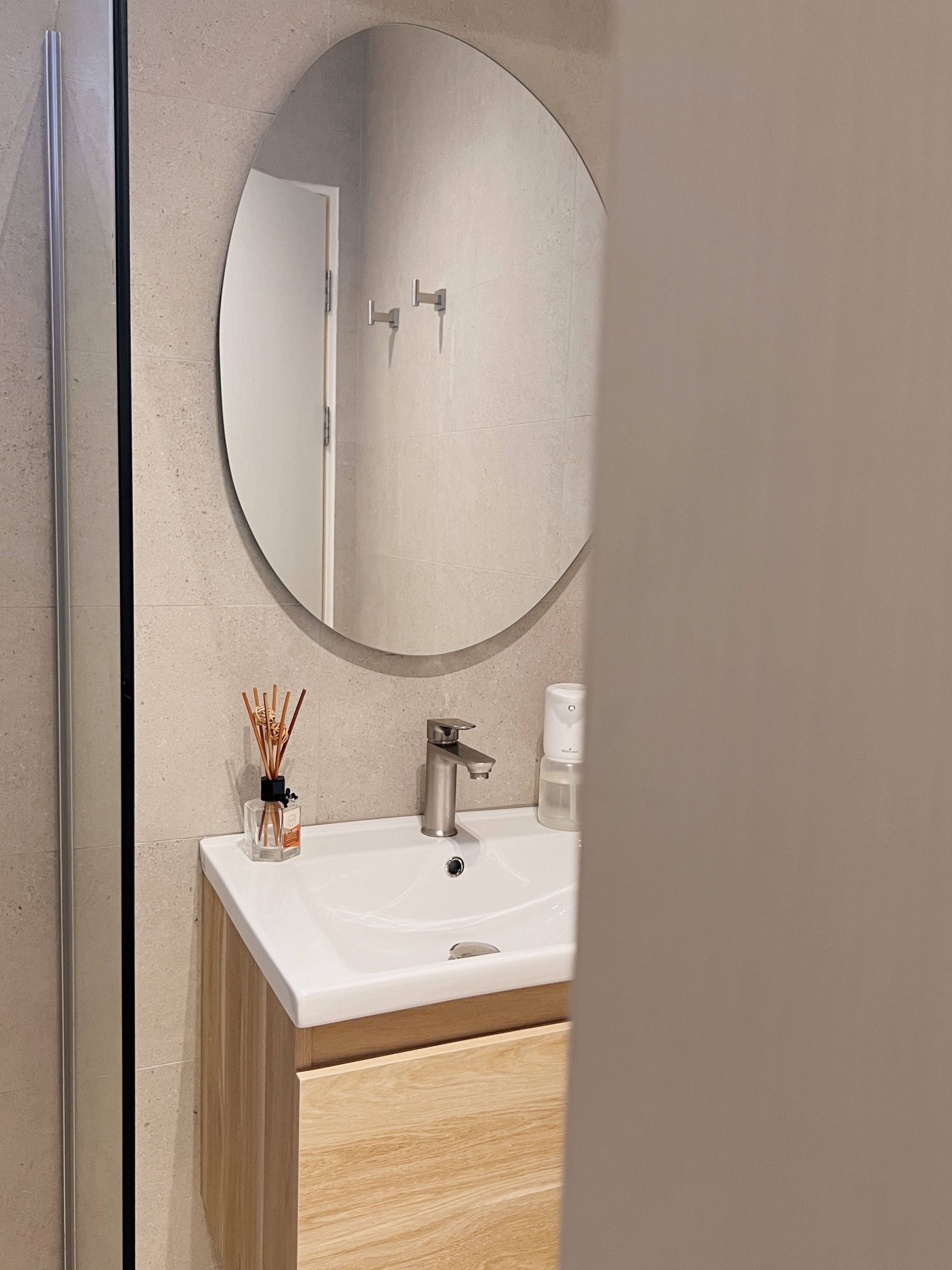 Entering a state of relaxation in our bathrooms - Bathroom vanity, modern design, white sink, round mirror, wooden cabinet