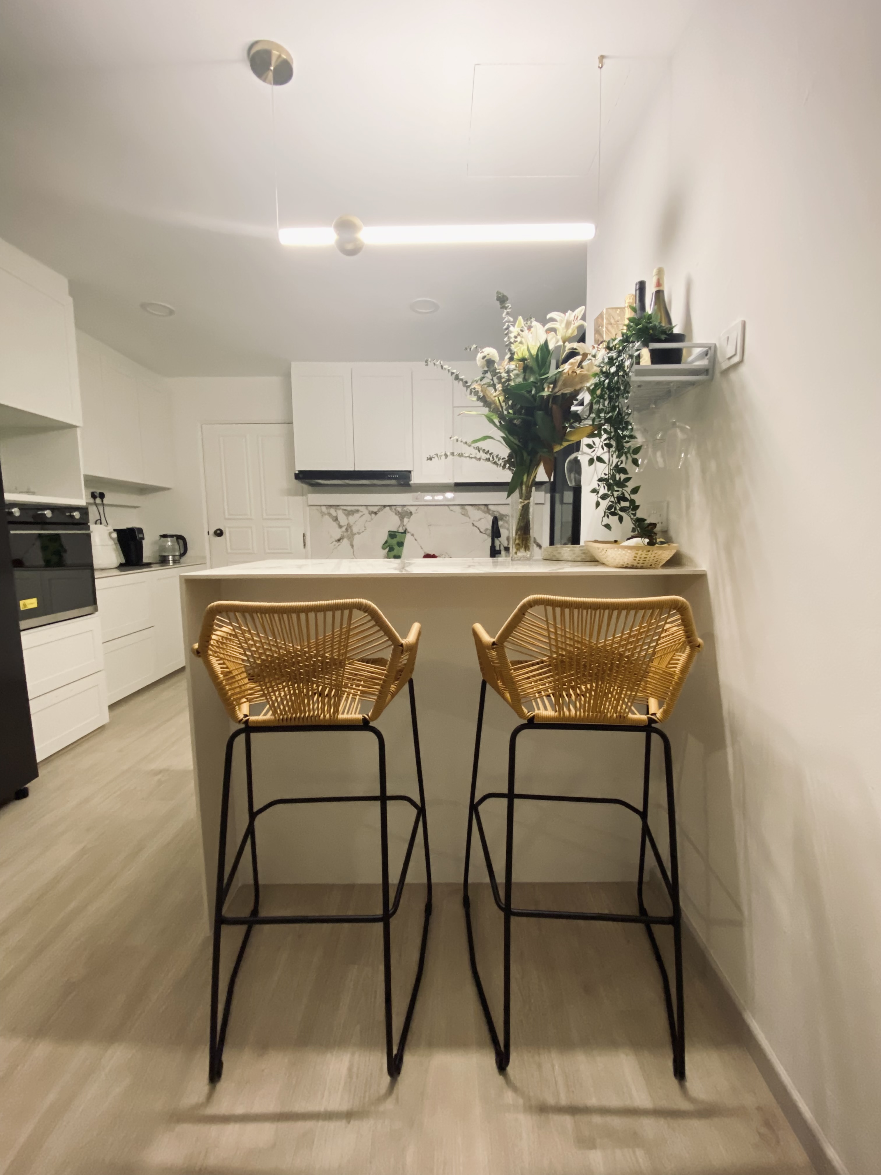 Functional kitchen with a mini bar - Modern kitchen with minimalist design, white cabinets, sleek appliances, black