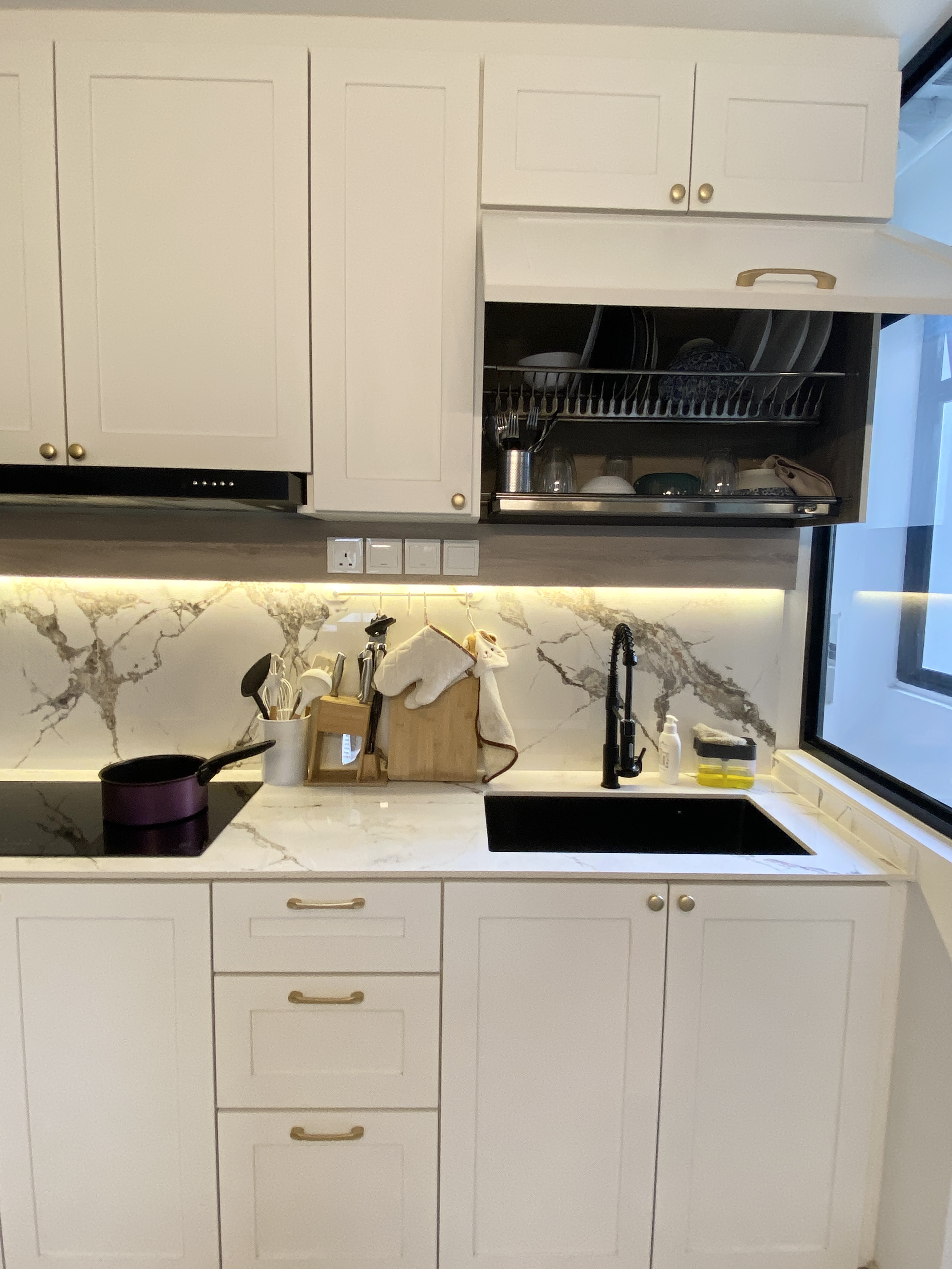 Functional kitchen with a mini bar - White kitchen cabinets, marble backsplash, modern design, under-cabinet lighting