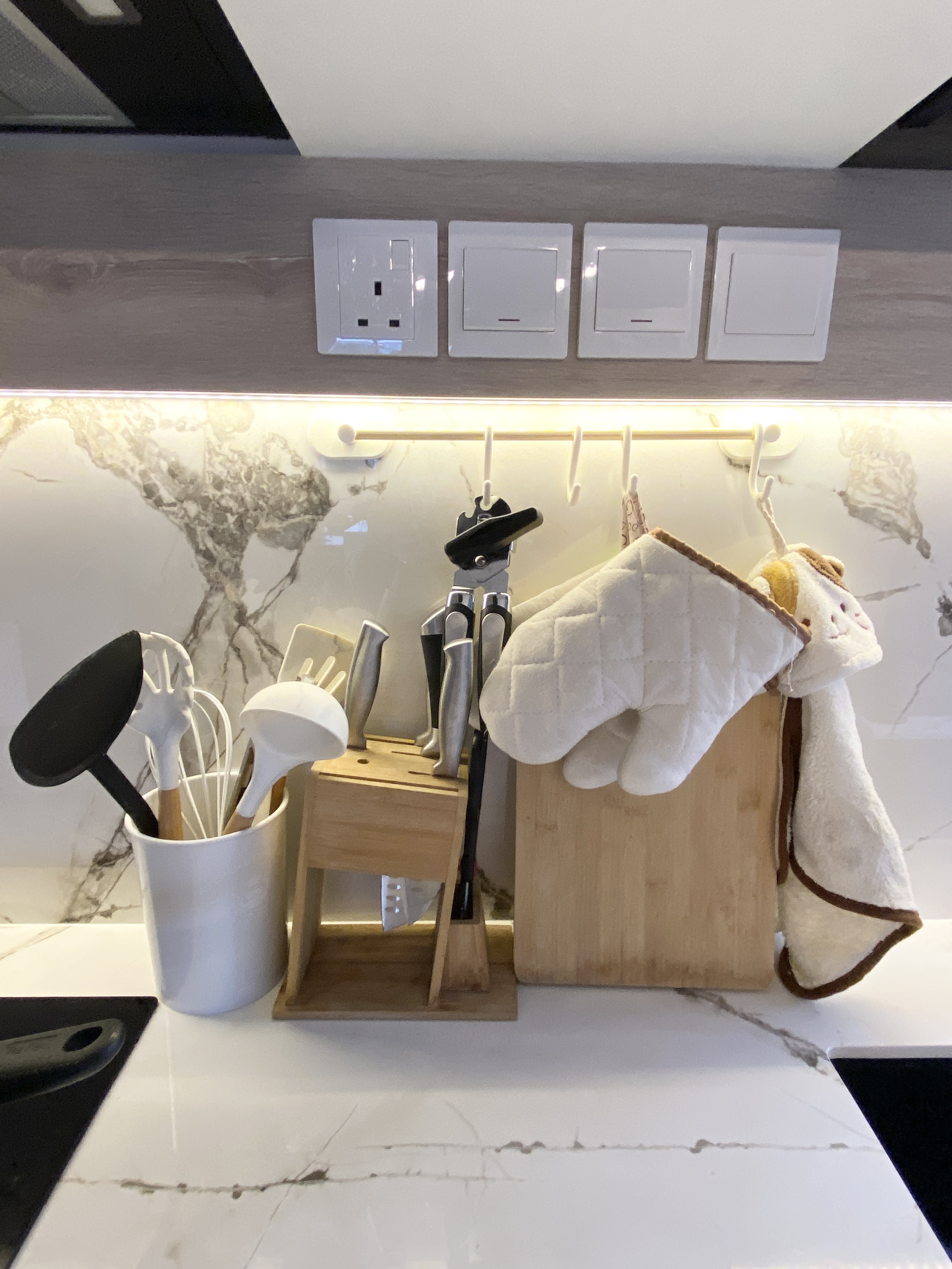 Functional kitchen with a mini bar - White kitchen countertop, modern design, stainless steel utensils, wooden cutting board