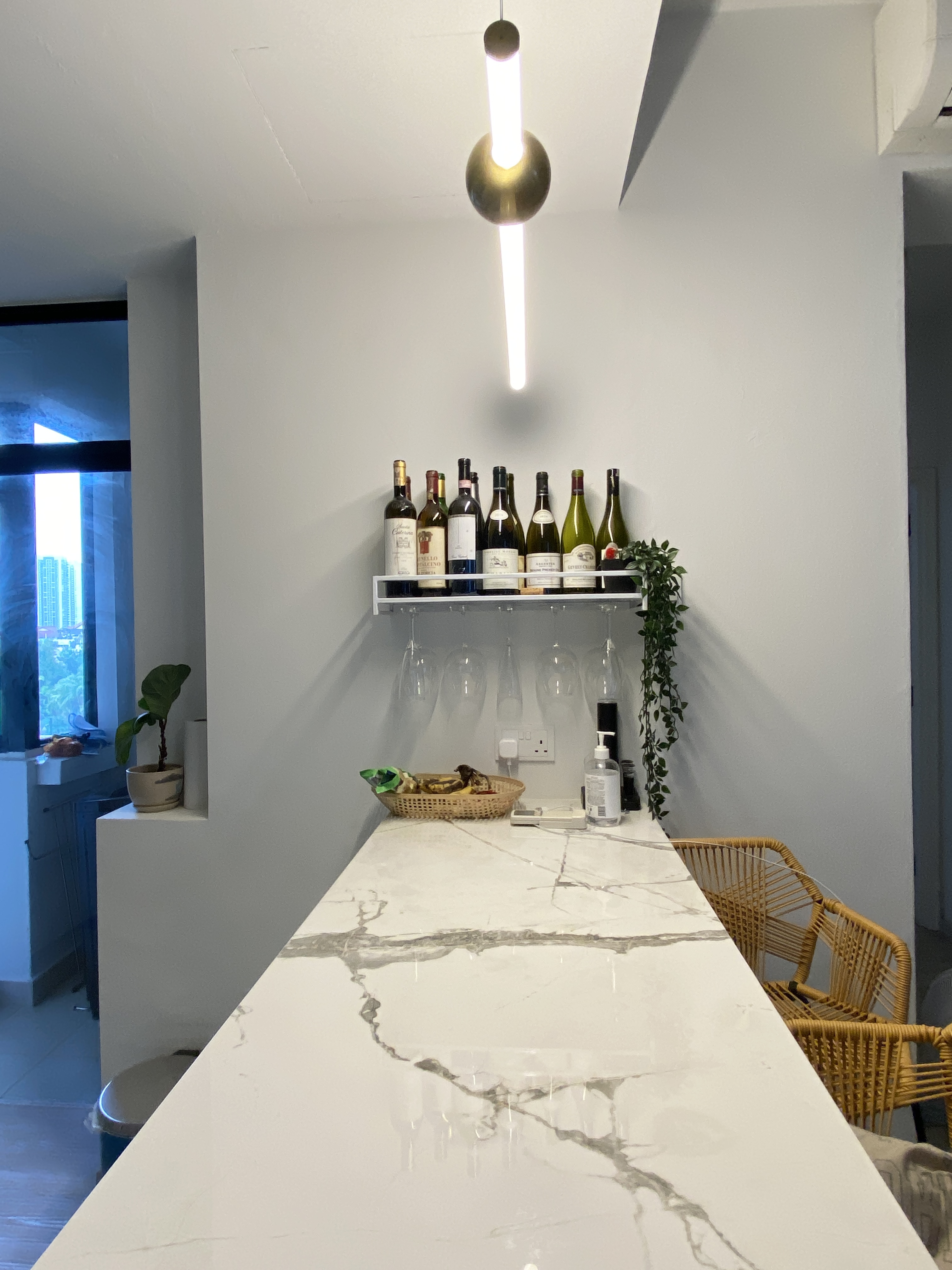 Functional kitchen with a mini bar - Modern kitchen countertop, minimalist design, white marble countertop, wine rack, wine