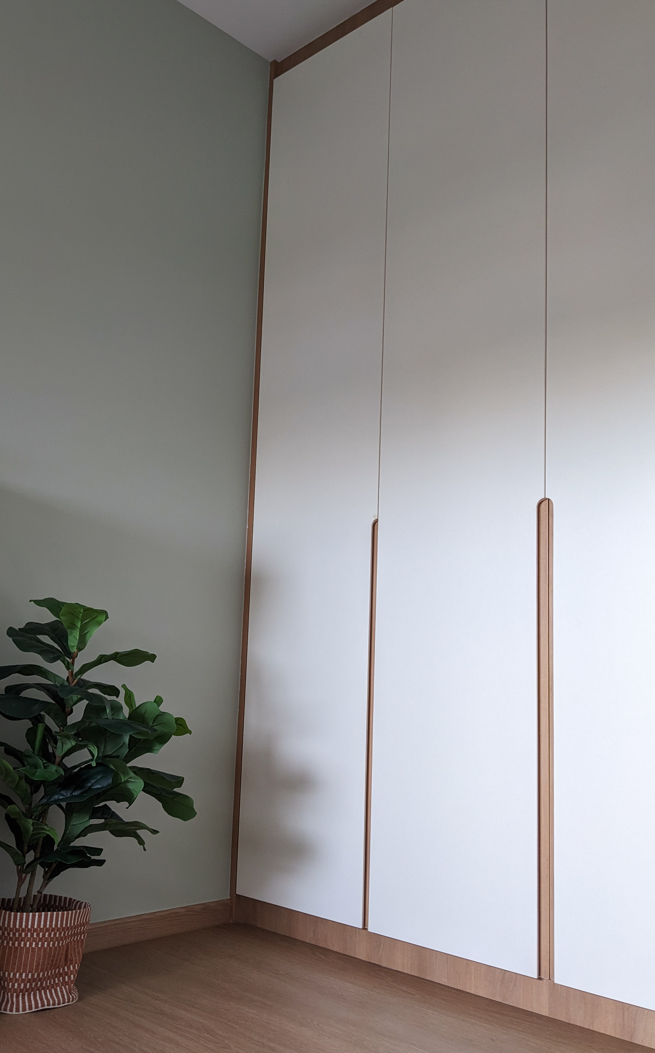 Child's Play | Flourish. Create. Connect. - White minimalist wardrobe with wooden accents, green potted plant, light green