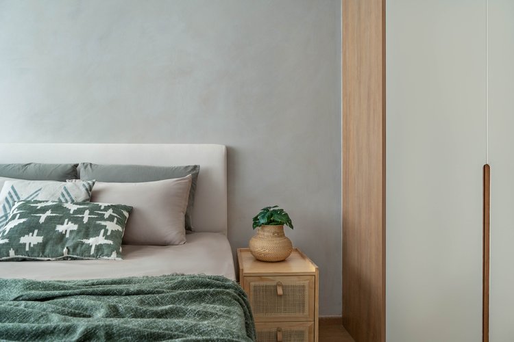 A Restful Night | Neutral & Natural - Light gray wall, minimalist design, cozy bed, green blanket, patterned pillows, wooden