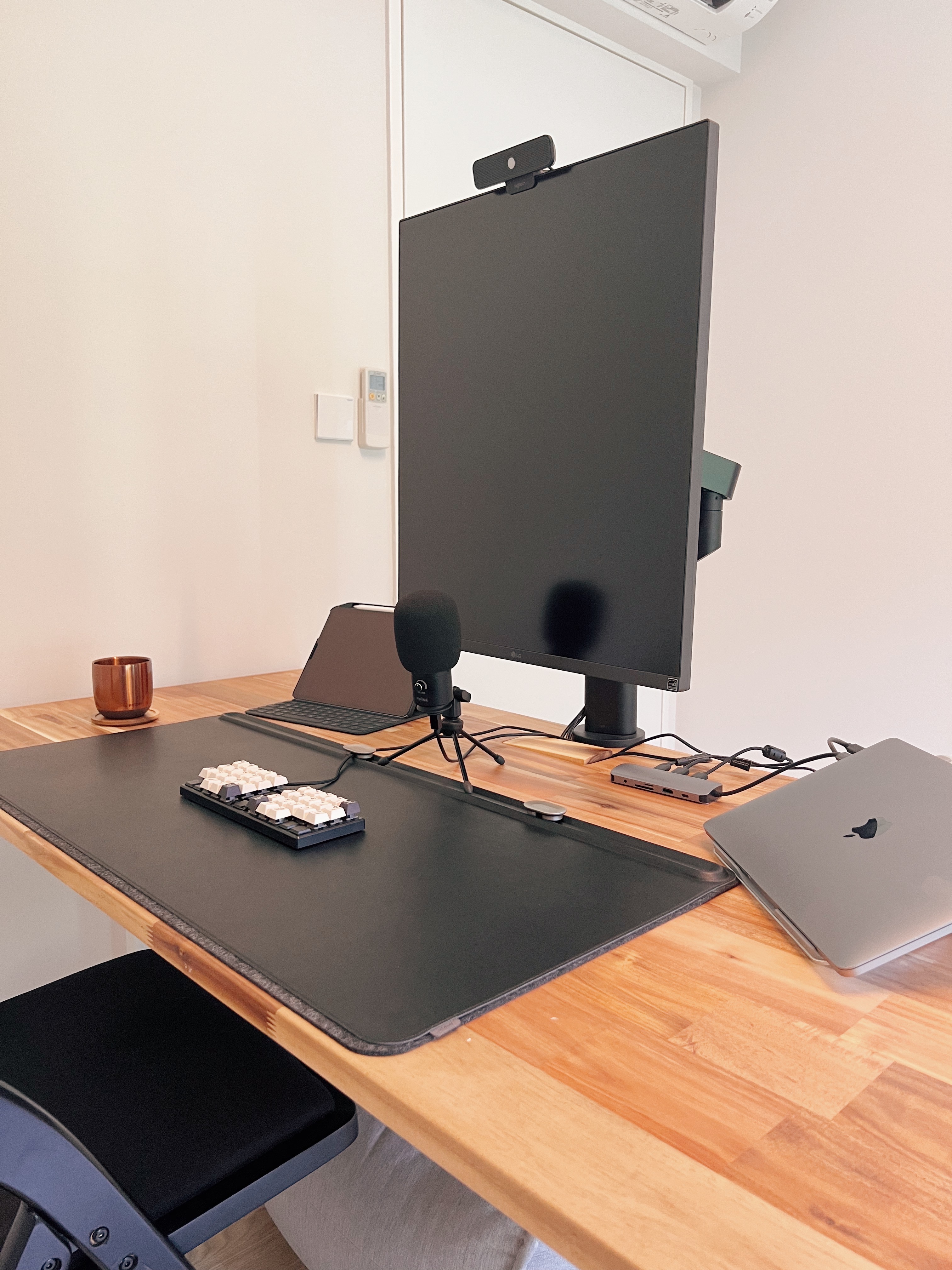 Finding focus in our home office - Black desk with ergonomic mouse pad, sleek monitor, wooden desk surface, modern workspace