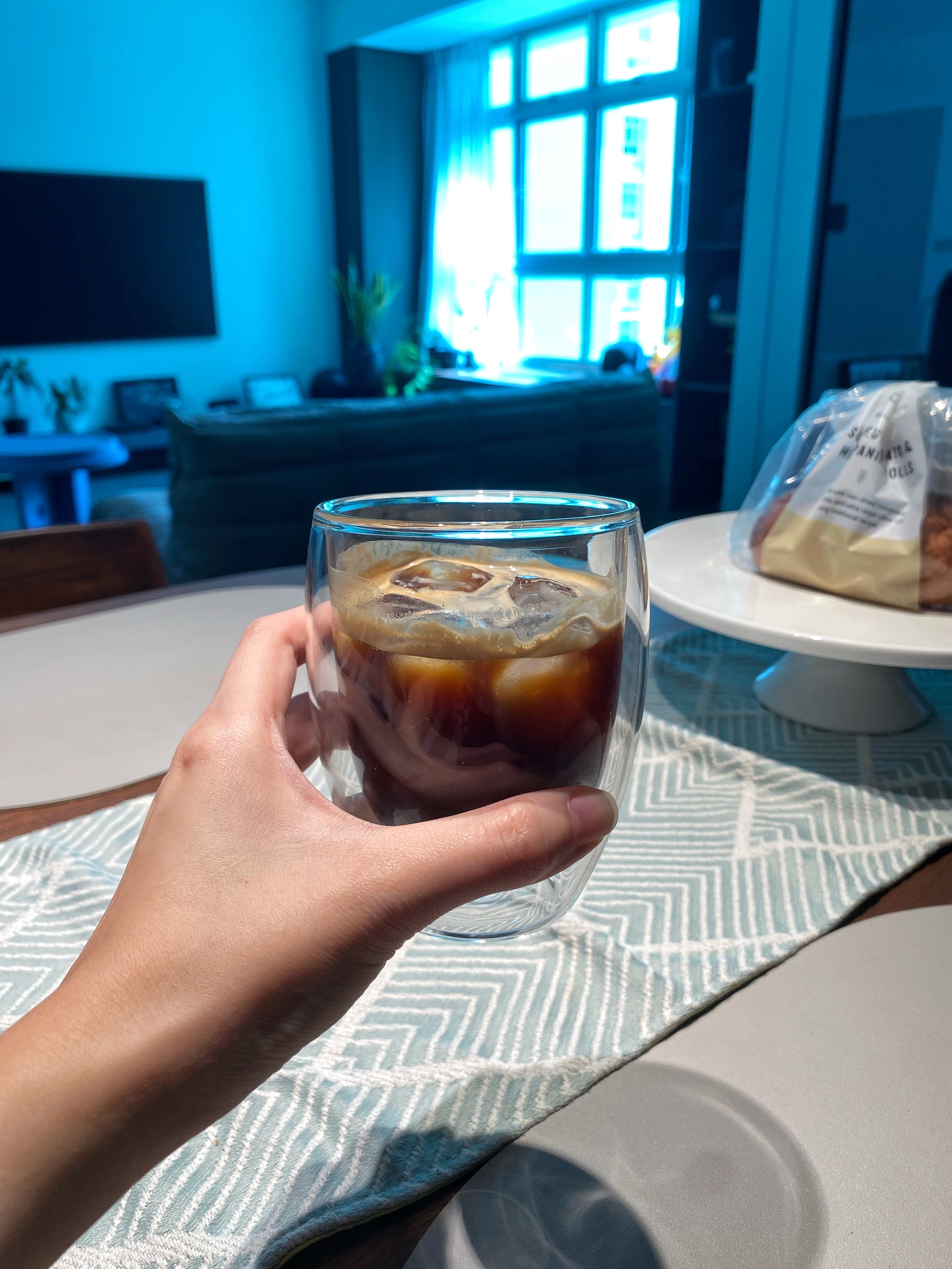 Our fun choice of morning routine - this is what we work hard for - glass of iced coffee, indoor setting, cozy atmosphere