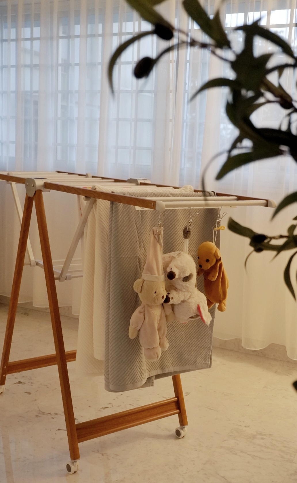 Favourite Purchases For The Home  - Baby crib with hanging toys, soft toys hanging on crib, wooden baby swing, white curtains