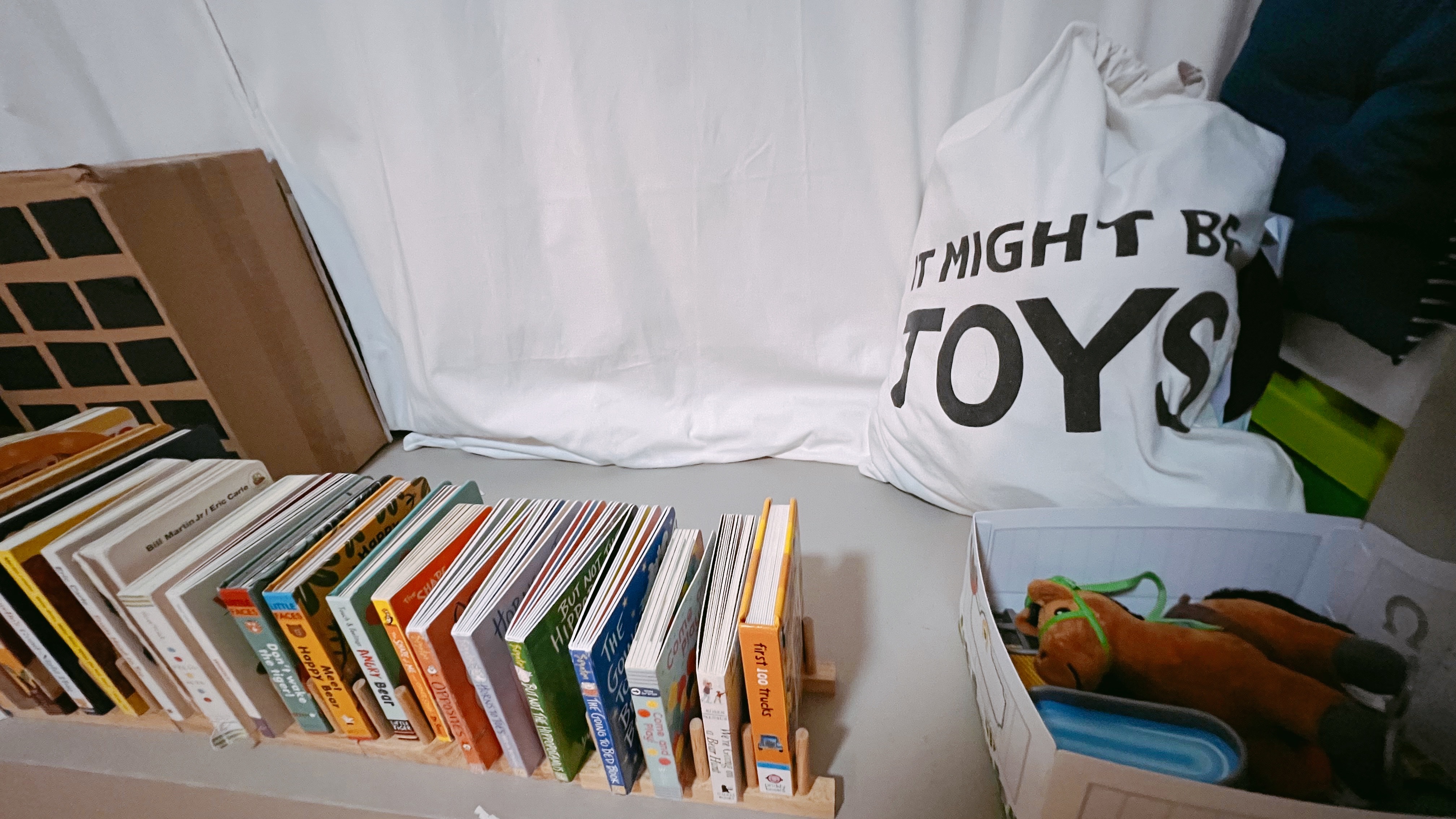 Welcome To Our Two Year Old’s Crib! - Children's books, stacked bookshelf, colorful spines, various book titles, children's