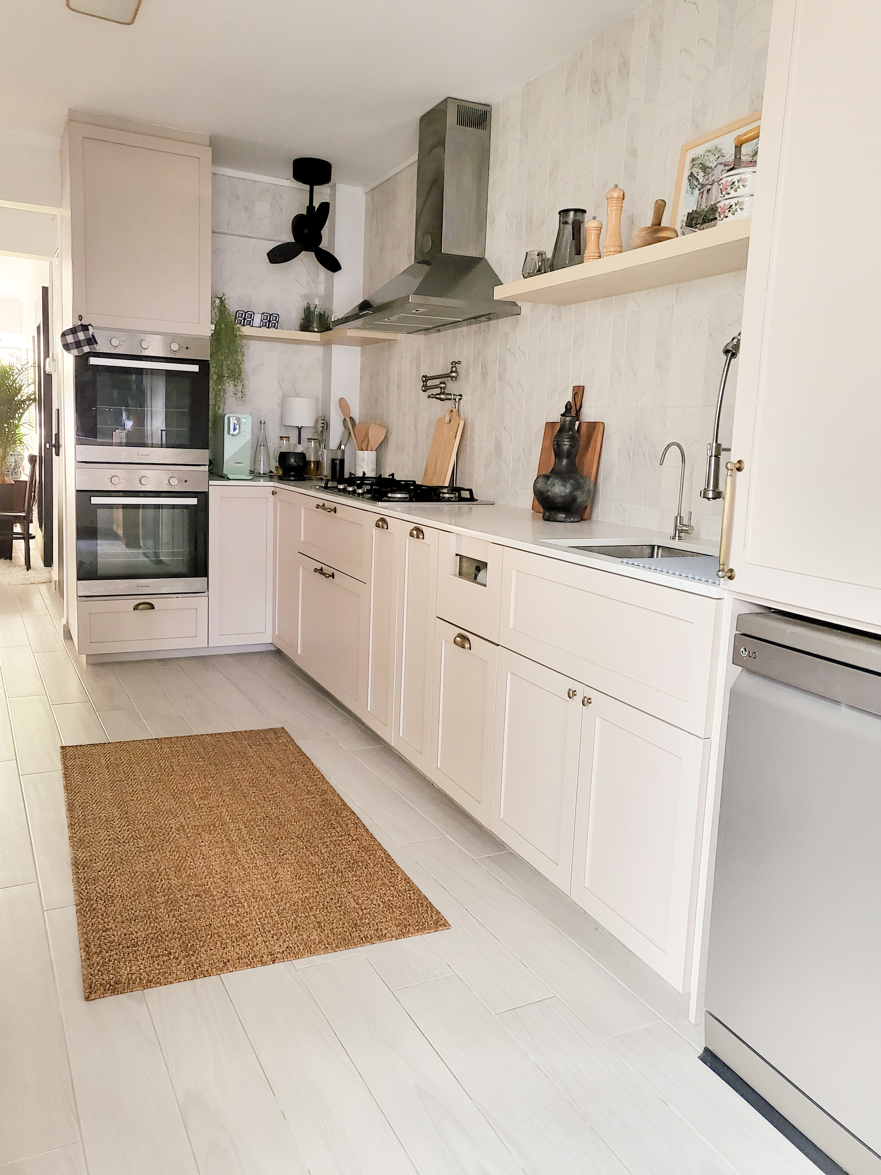 Flipping the House to Our Home - White kitchen with modern appliances, built-in oven and range hood, light wood cabinets