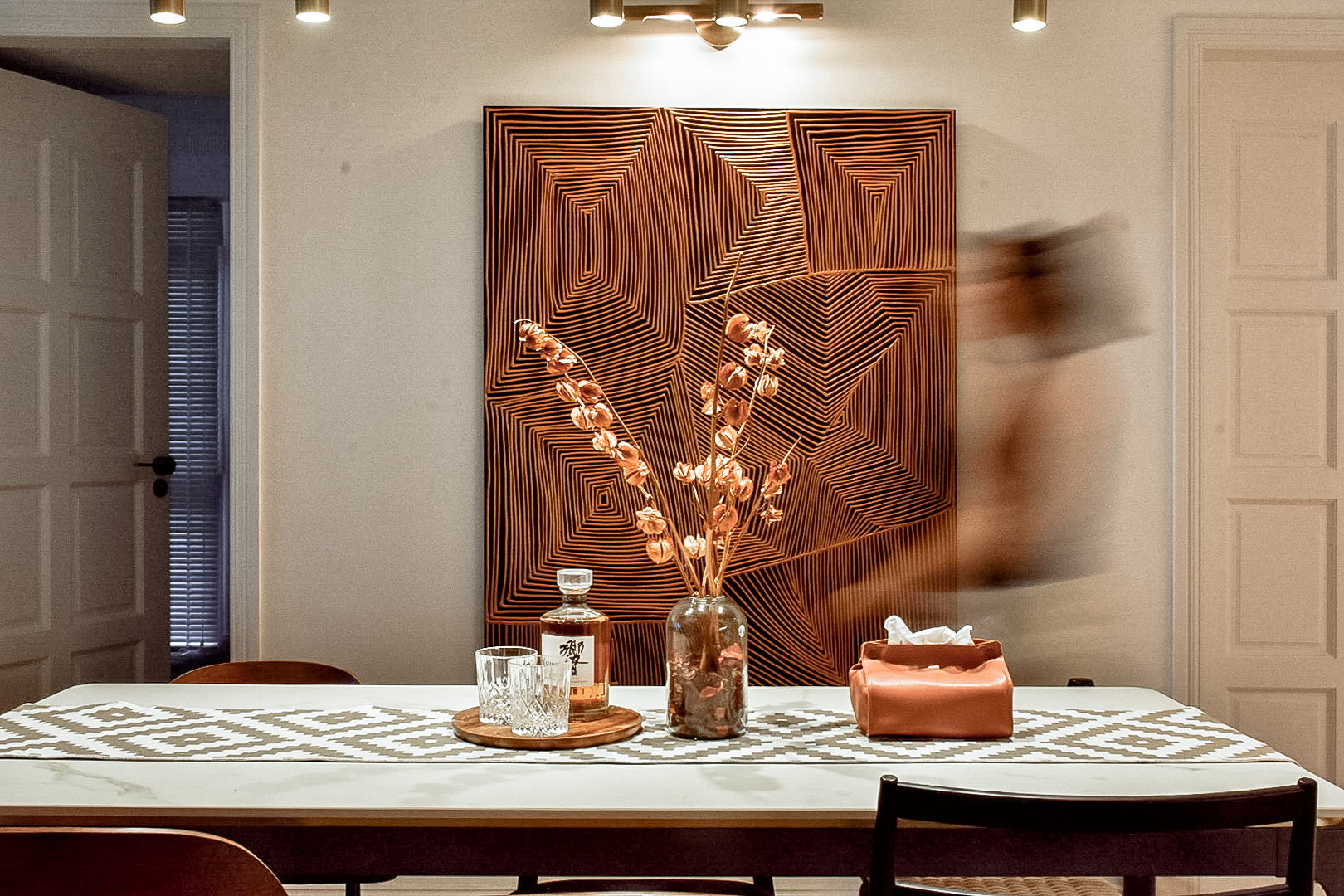 Gather - Dine  - Delight - modern dining room, abstract art, geometric pattern, warm lighting, wooden door, minimalist decor