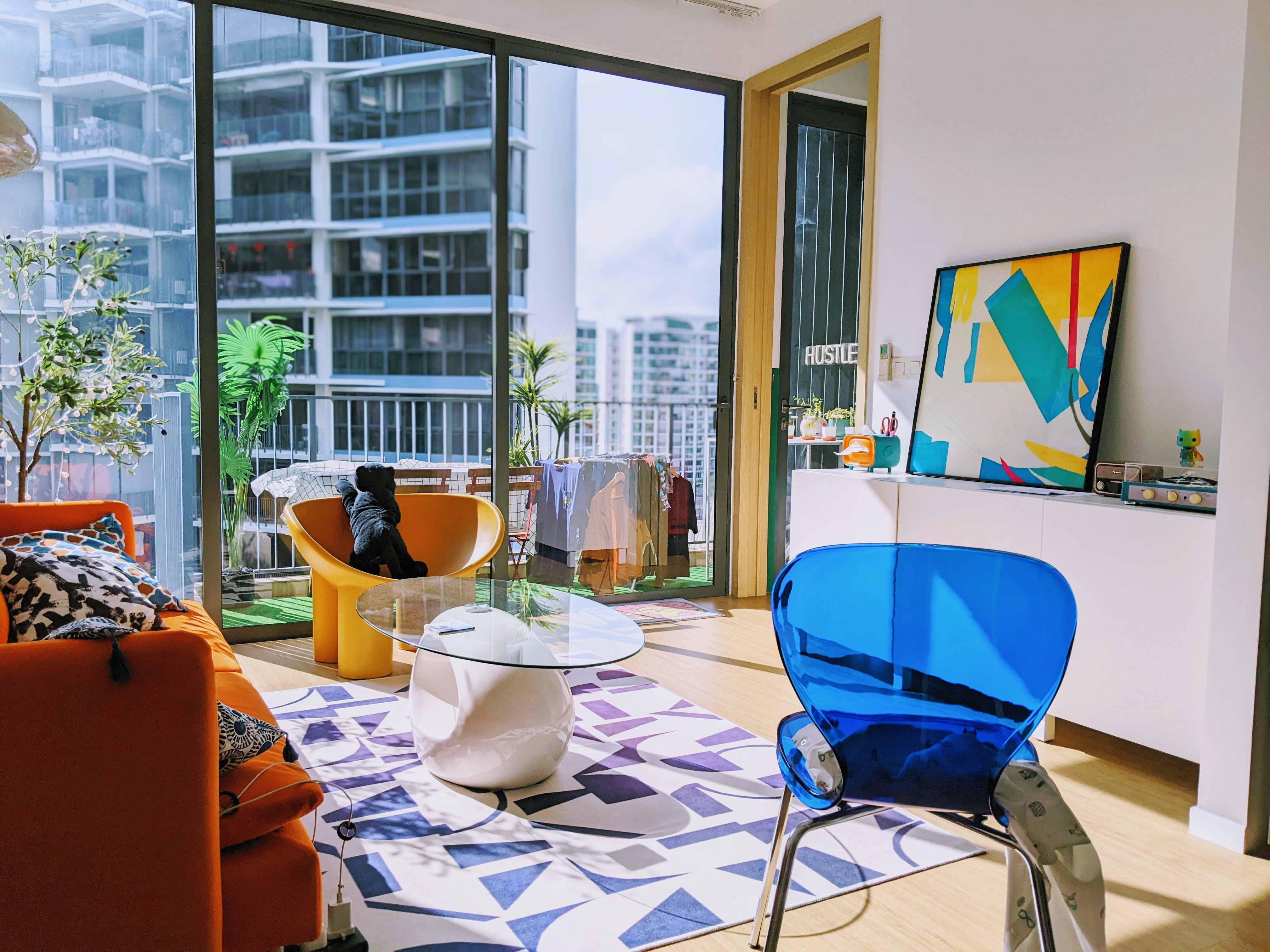 Self-Designing A Bold Vibrant 2-Bedder With a 23K Budget - Modern living room with large windows, vibrant orange and blue