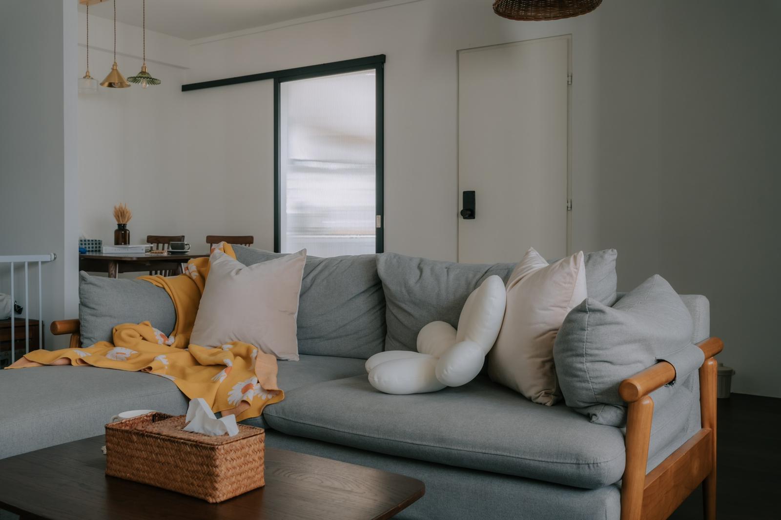 Sleepy & Cozy 5-room Resale | Mid-Century Boho Reno <40K - Modern living room with gray sofa, yellow blanket, white pillows