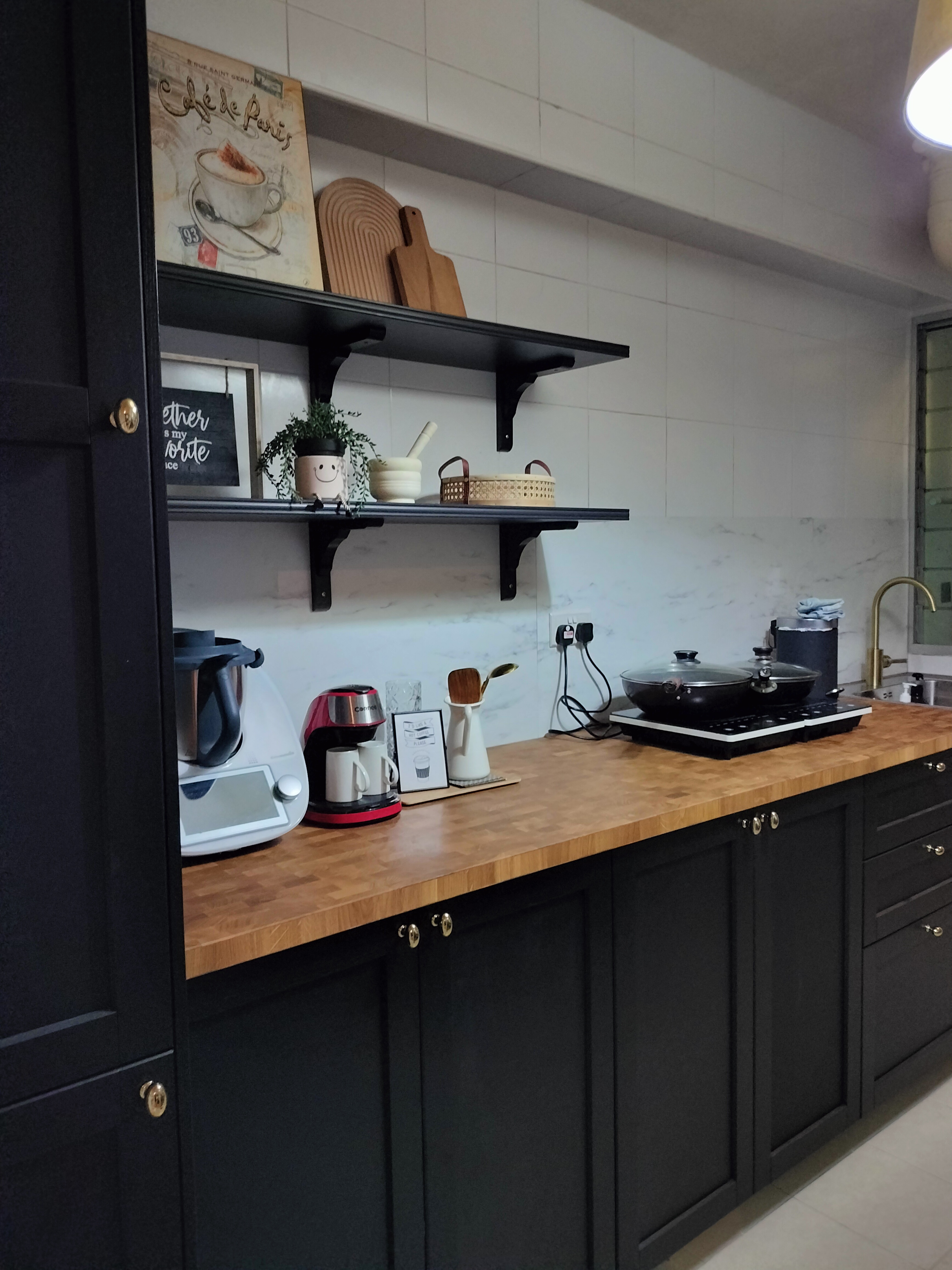 The kitchen - black kitchen cabinetry, modern design, wooden countertop, black appliances, white coffee maker, red and black