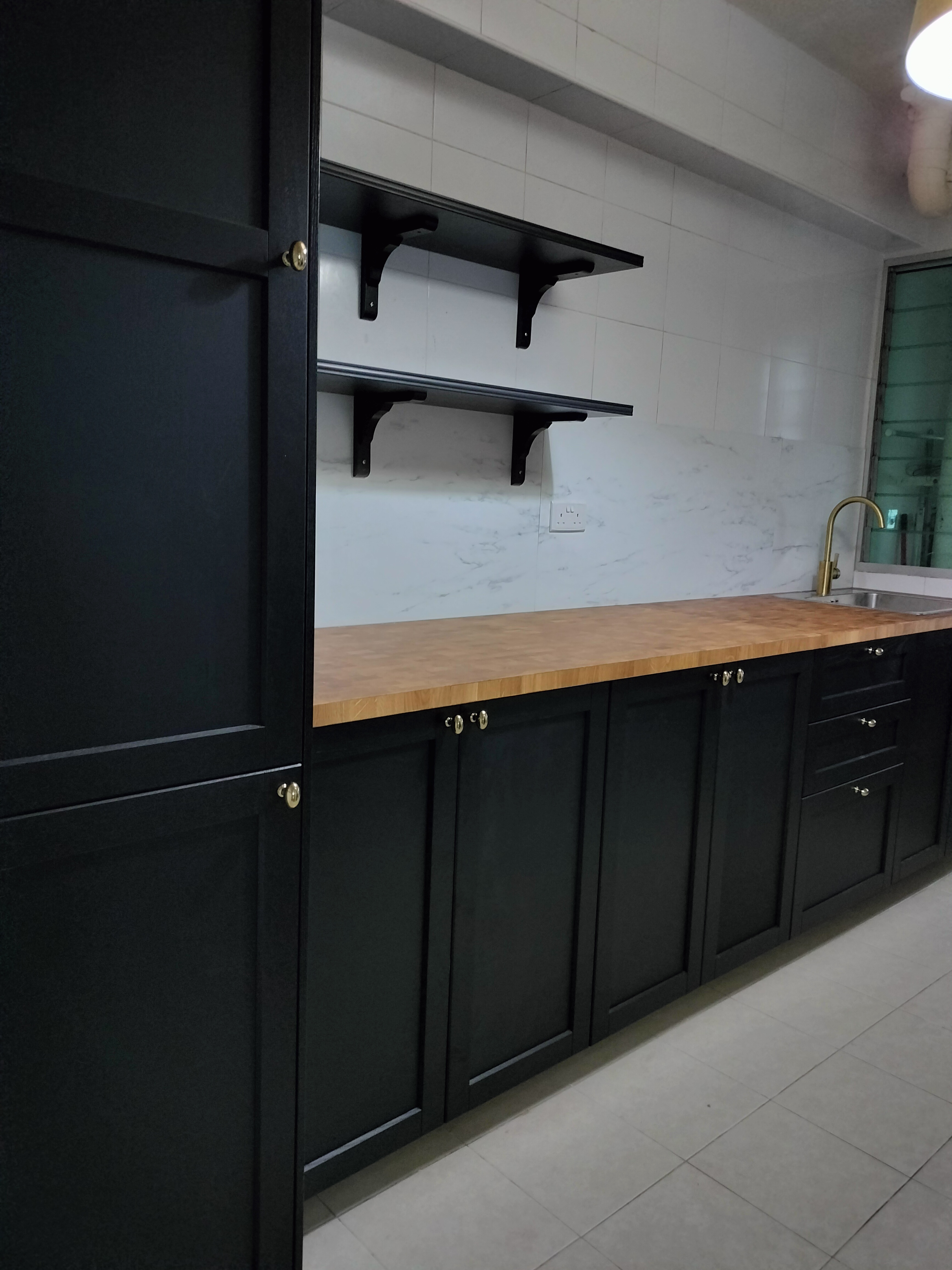 The kitchen - Dark kitchen cabinetry, marble backsplash, wooden countertop, black metal shelves, modern faucet, stainless
