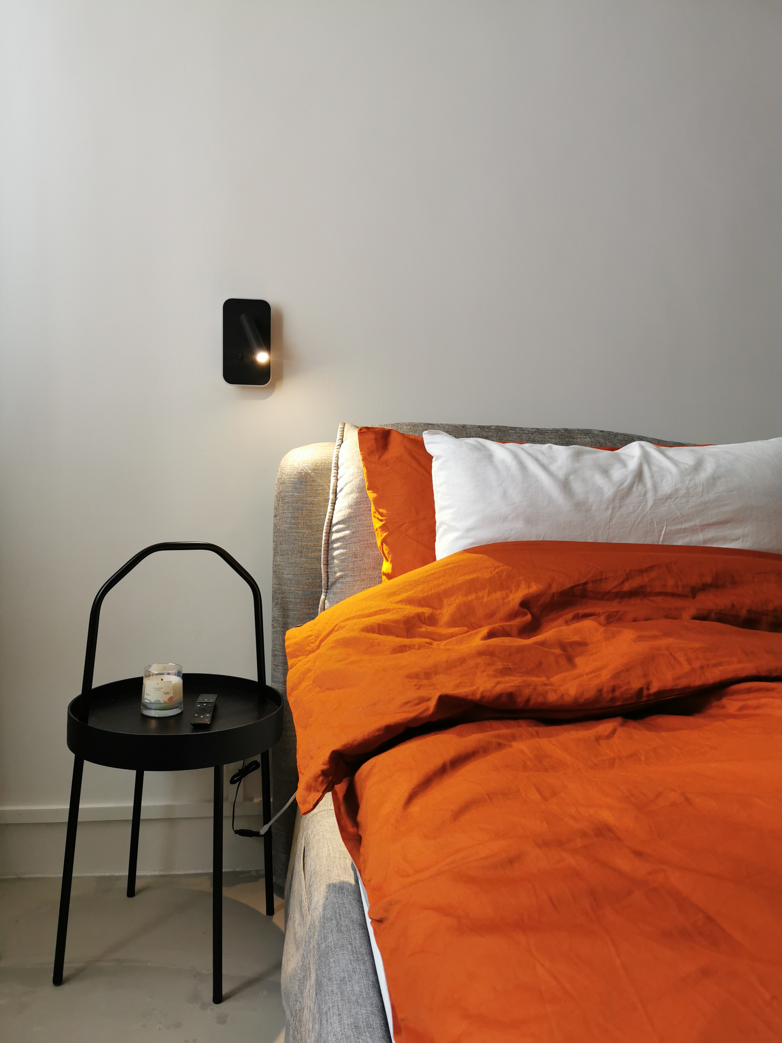 5 Lighting Ideas to Create Mood in your Home - modern bedroom, cozy bed, orange comforter, white pillows, black bedside