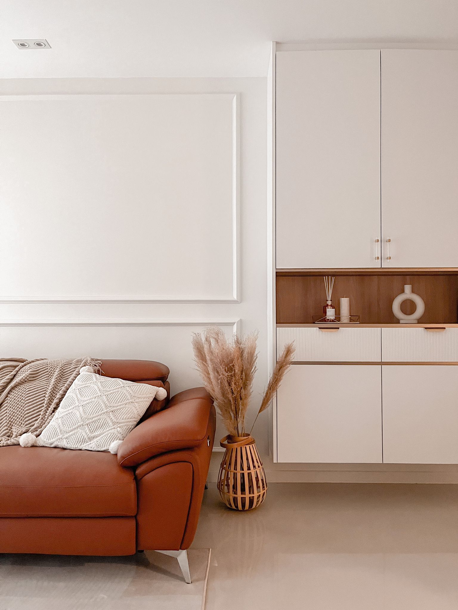 Light Luxury Family Home in the East - Cream and brown leather sofa, minimalist decor, cozy throw blanket, textured white