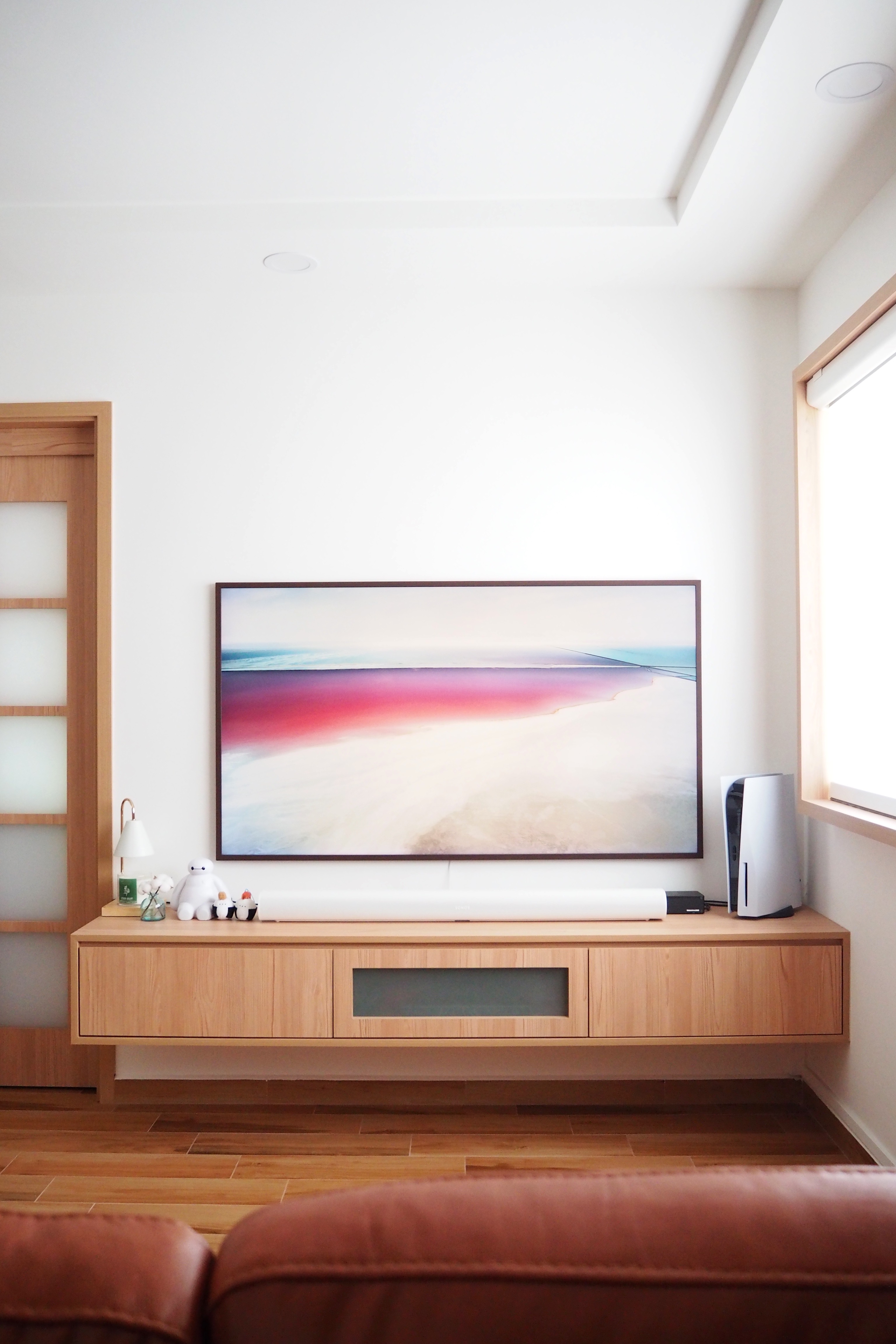 Heart of Our Home — Living Room - Modern minimalist living room, sleek entertainment center, abstract painting, natural light