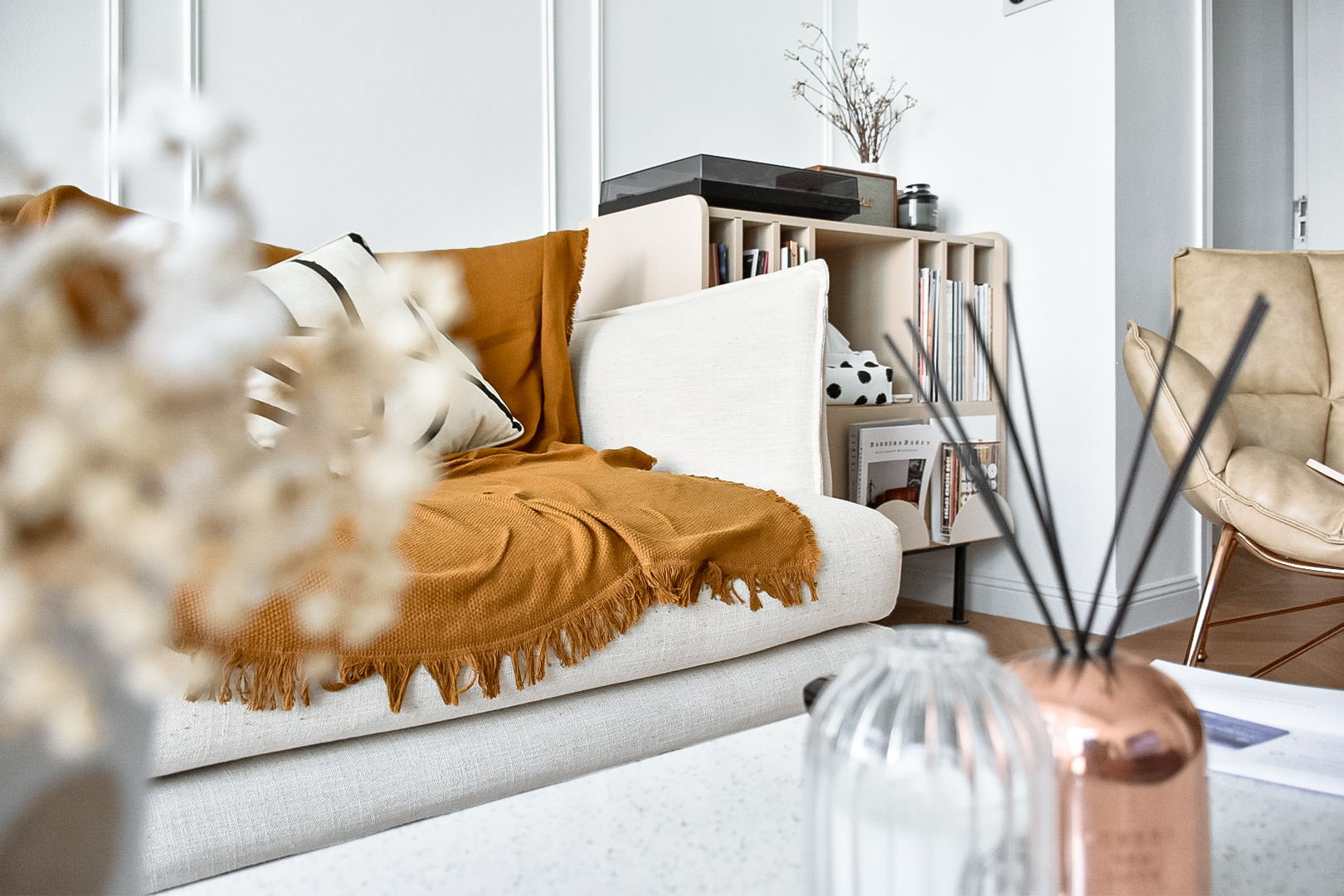 Tips and Tricks for a Stylish Sanctuary - Cream sofa, mustard blanket, beige pillows, modern decor, white walls, minimalist