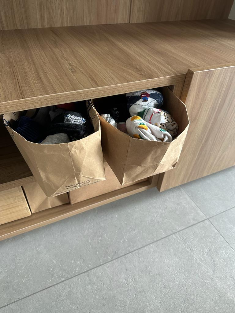 Living in simplicity where less is more - Wooden cabinet, brown paper bags, neatly organized, laundry supplies, socks