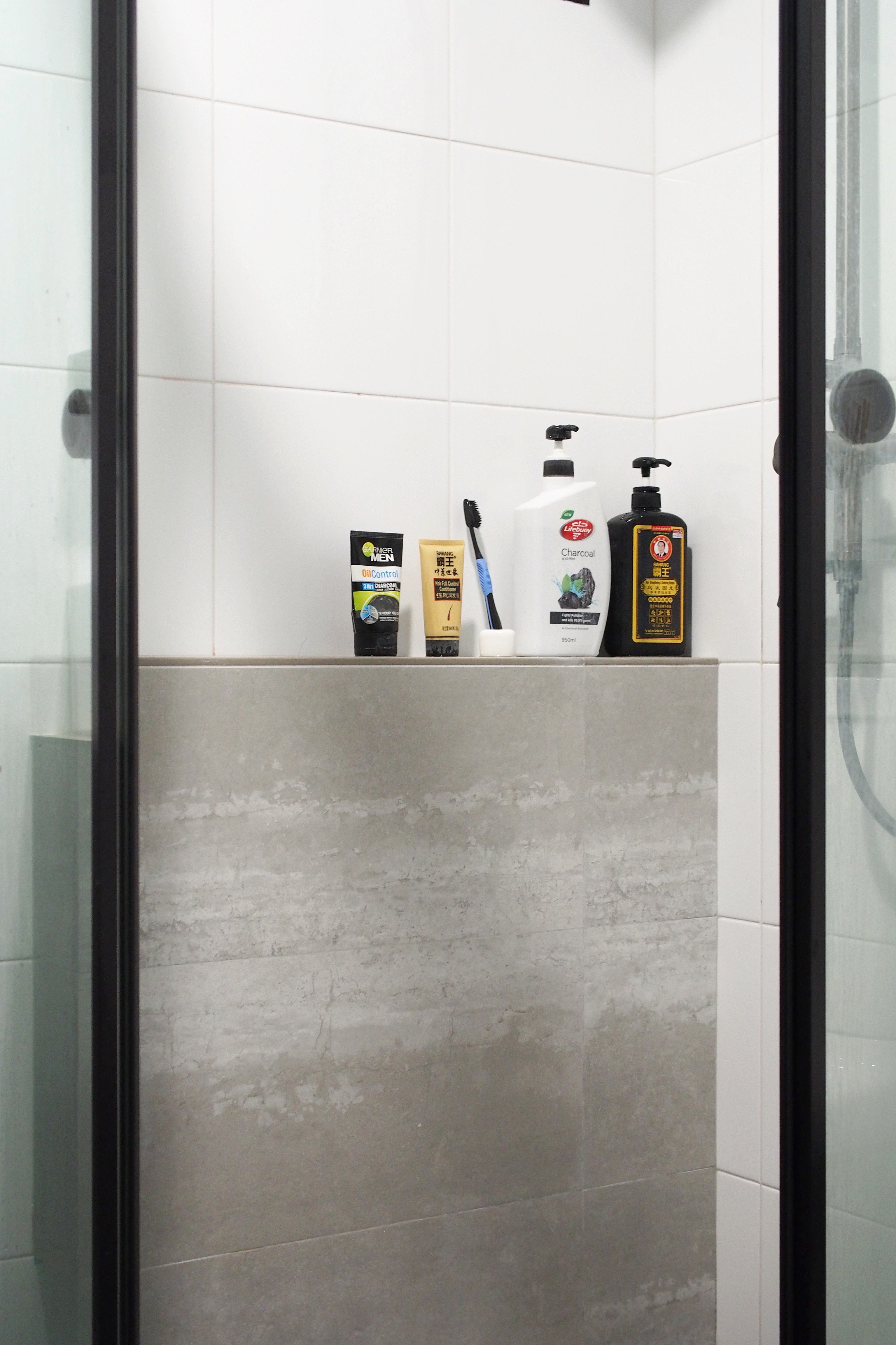 Making a bathroom with HDB fittings work - Shower counter, toiletries, bathroom shelf, white tiles, gray tiles, bathroom