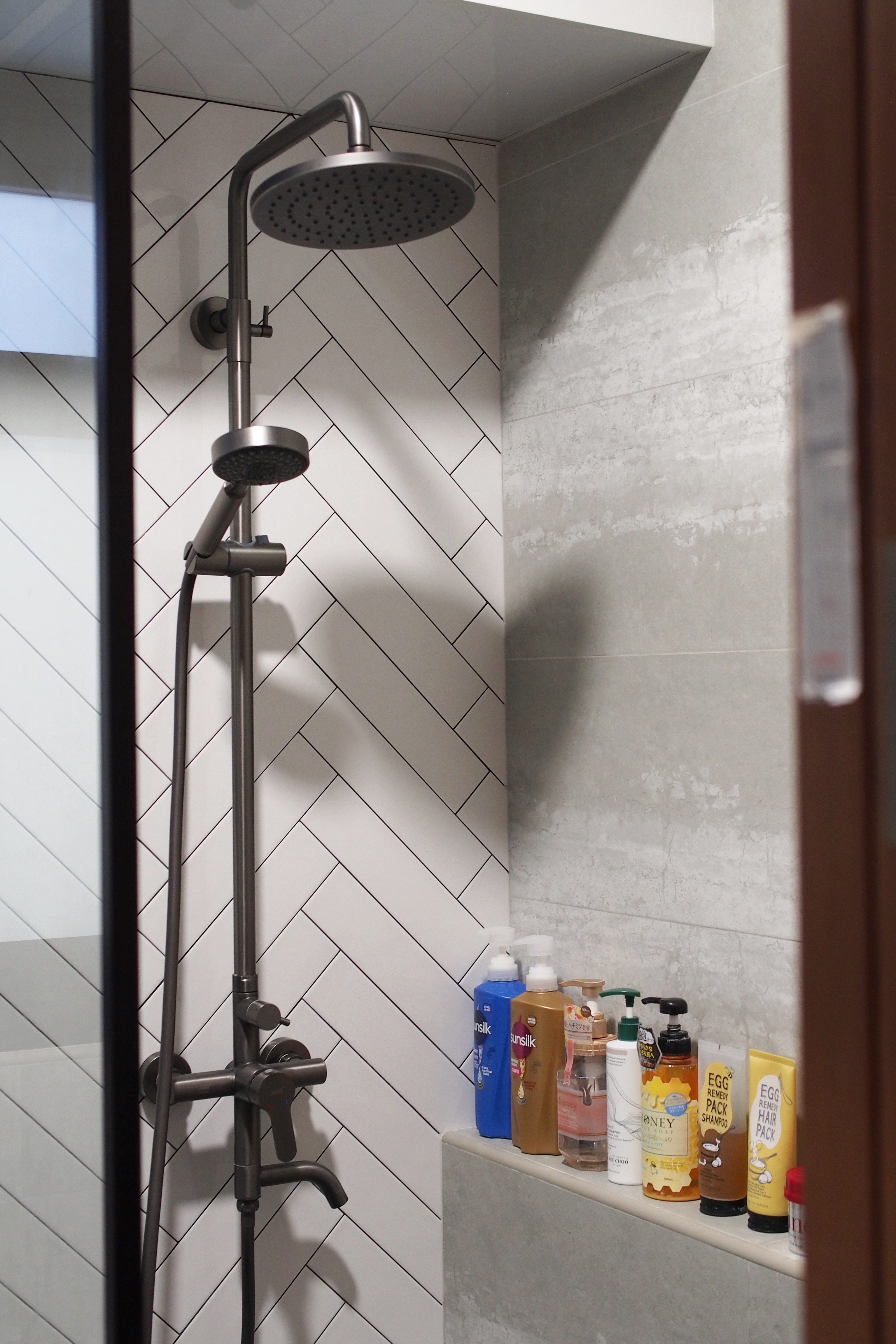 Making a bathroom with HDB fittings work - shower head, modern bathroom, tiled wall, black and white design, dual showerhead