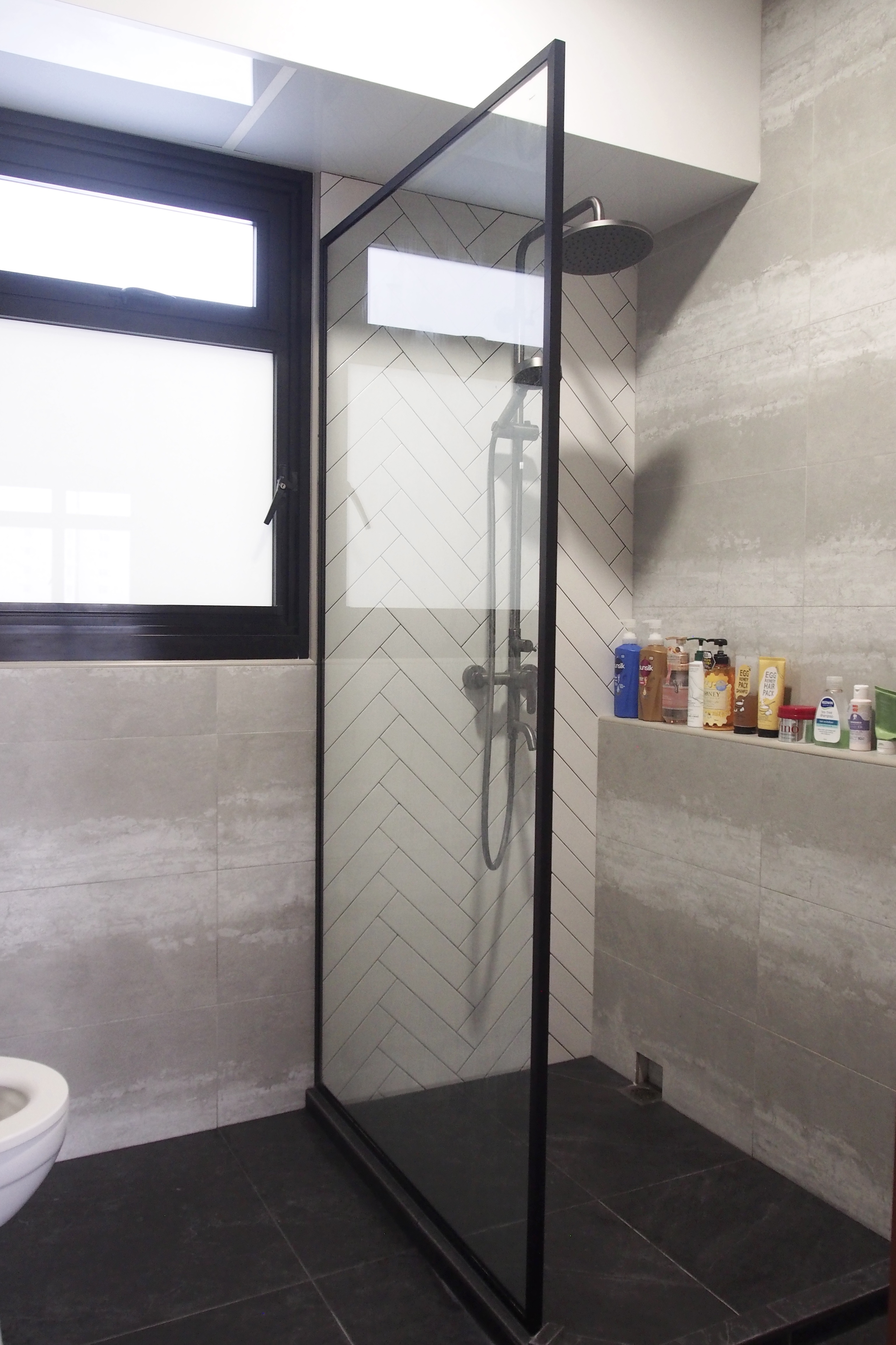 Making a bathroom with HDB fittings work - Modern bathroom with sleek glass shower enclosure, black frame, white and gray