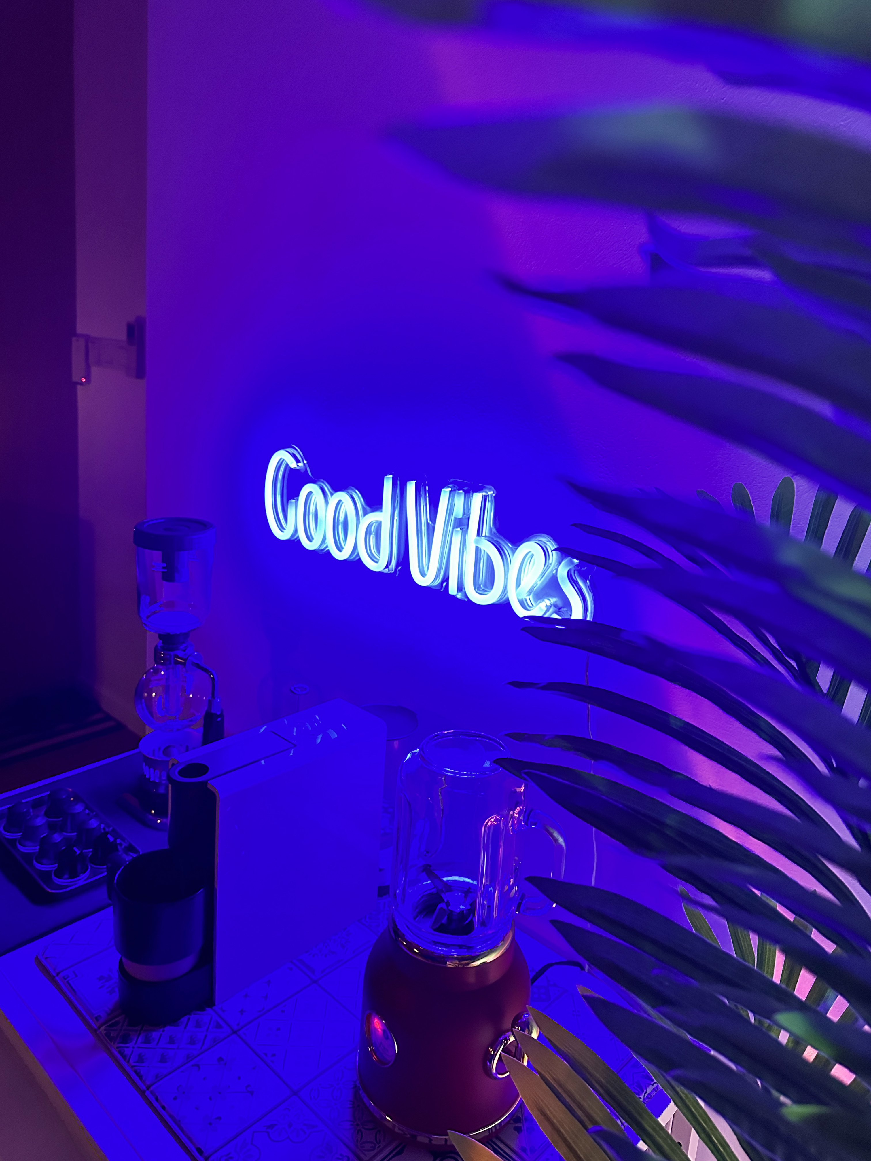 Our Happy Aesthetic Coffee Corner & Entryway - Neon sign "Good Vibes" illuminated in vibrant blue light, surrounded by a