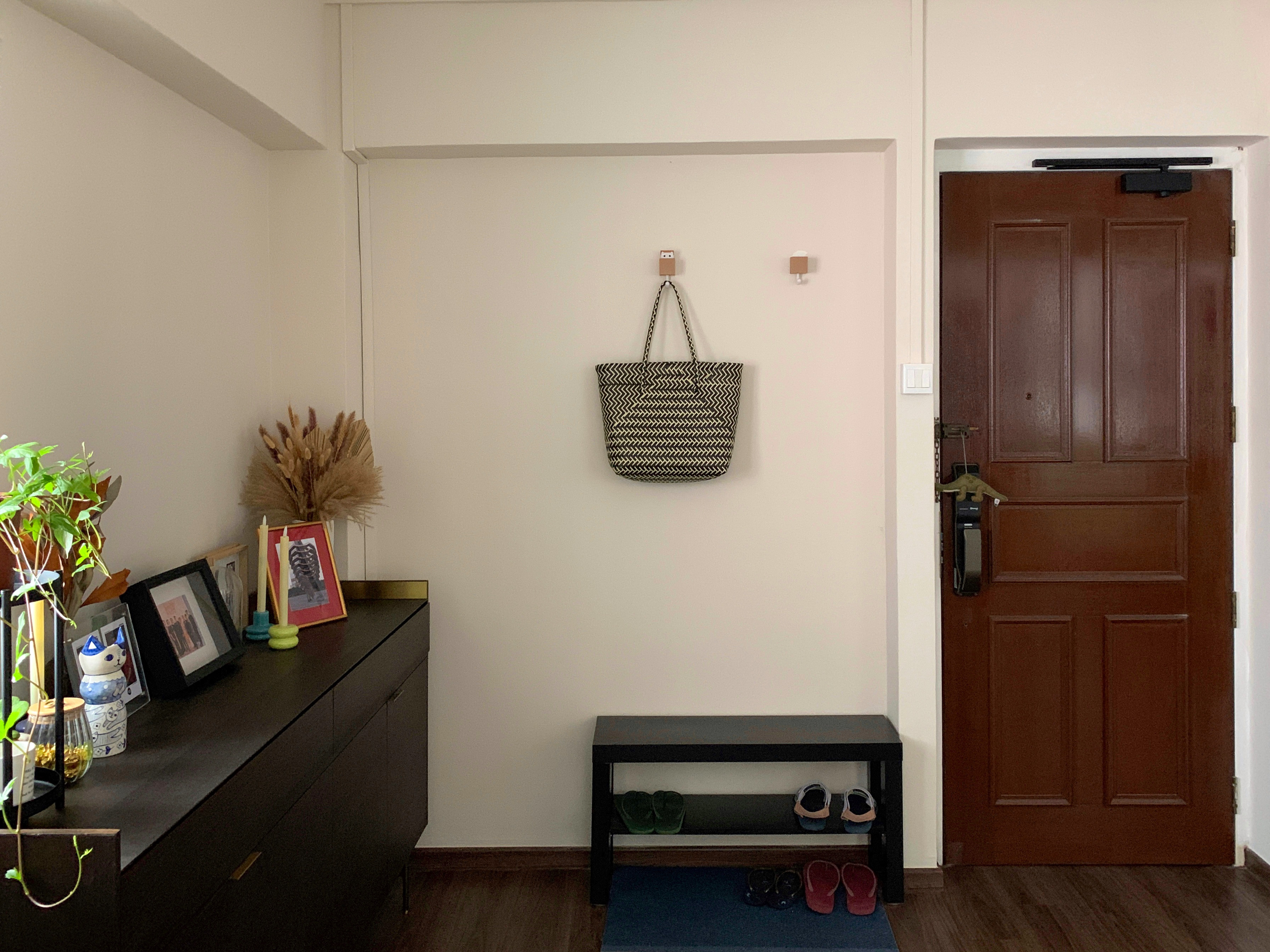 Creating a clean and functional yet personalised entryway  - vintage wooden dresser, black and white woven bag, framed