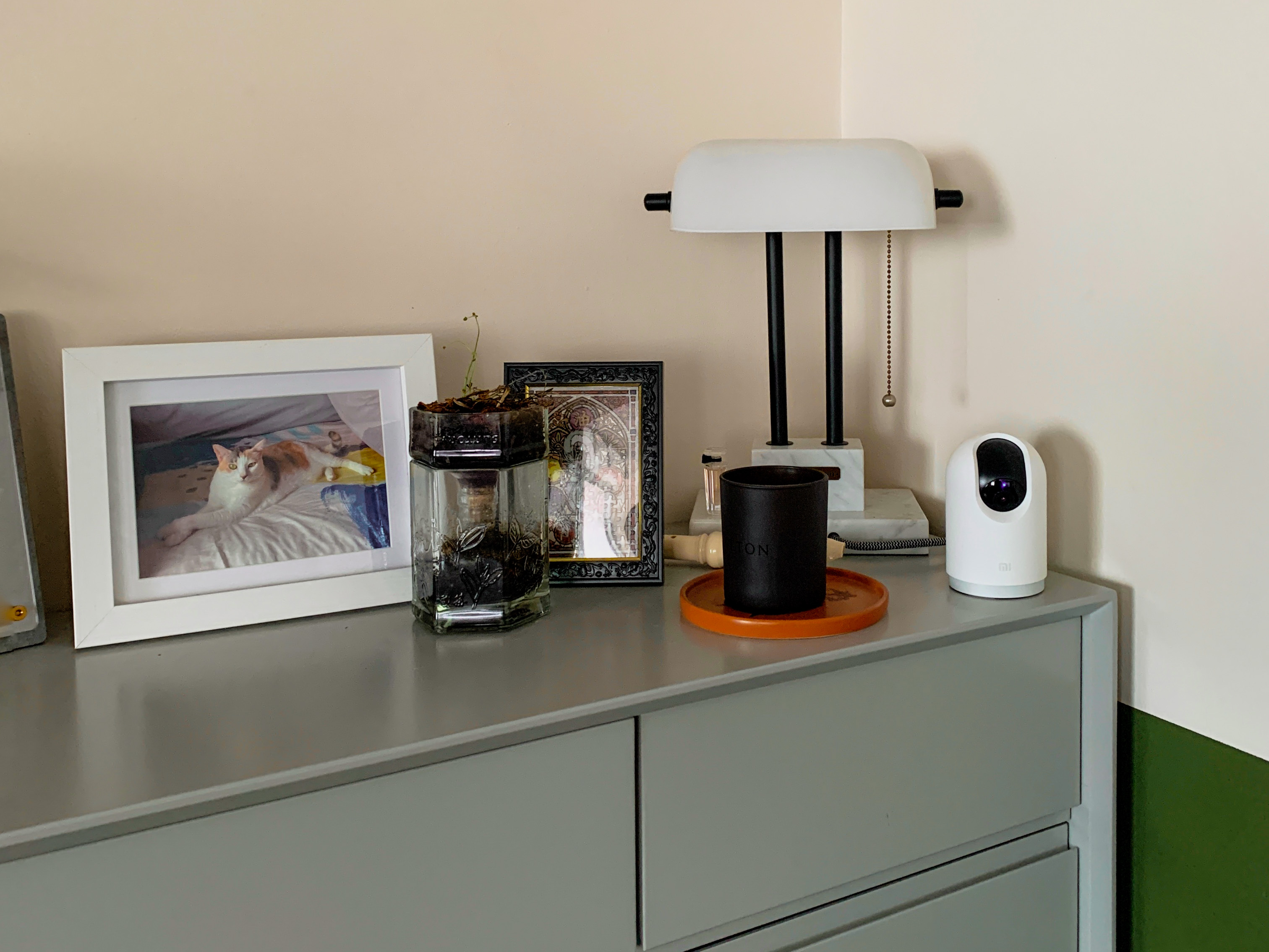Creating a clean and functional yet personalised entryway  - White lamp with black legs, framed photo of cat, glass jar with