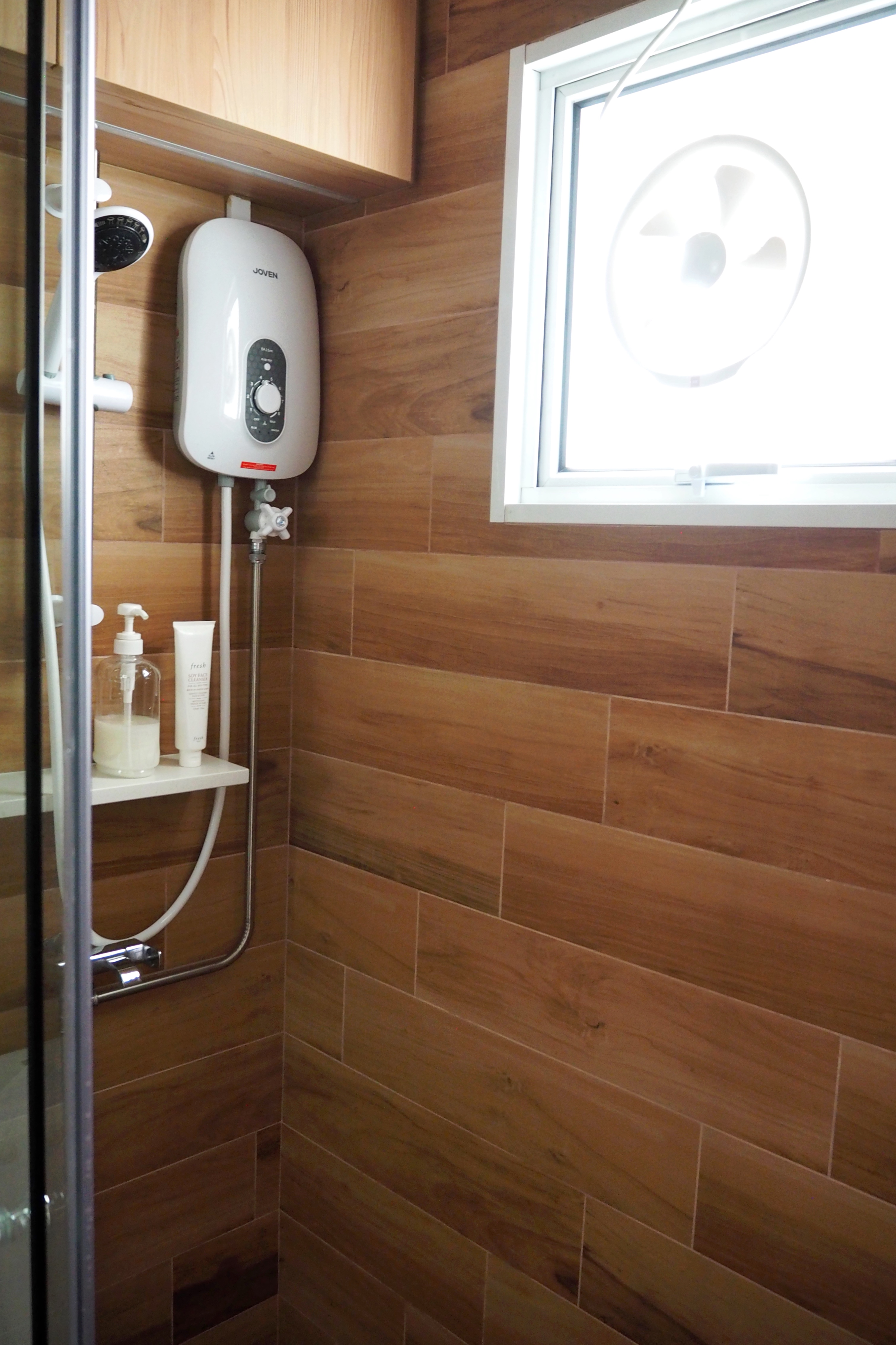 Bathrooms with Japanese Bath Vibes - Shower area with built-in heater, wooden panel walls, white showerhead, white tank