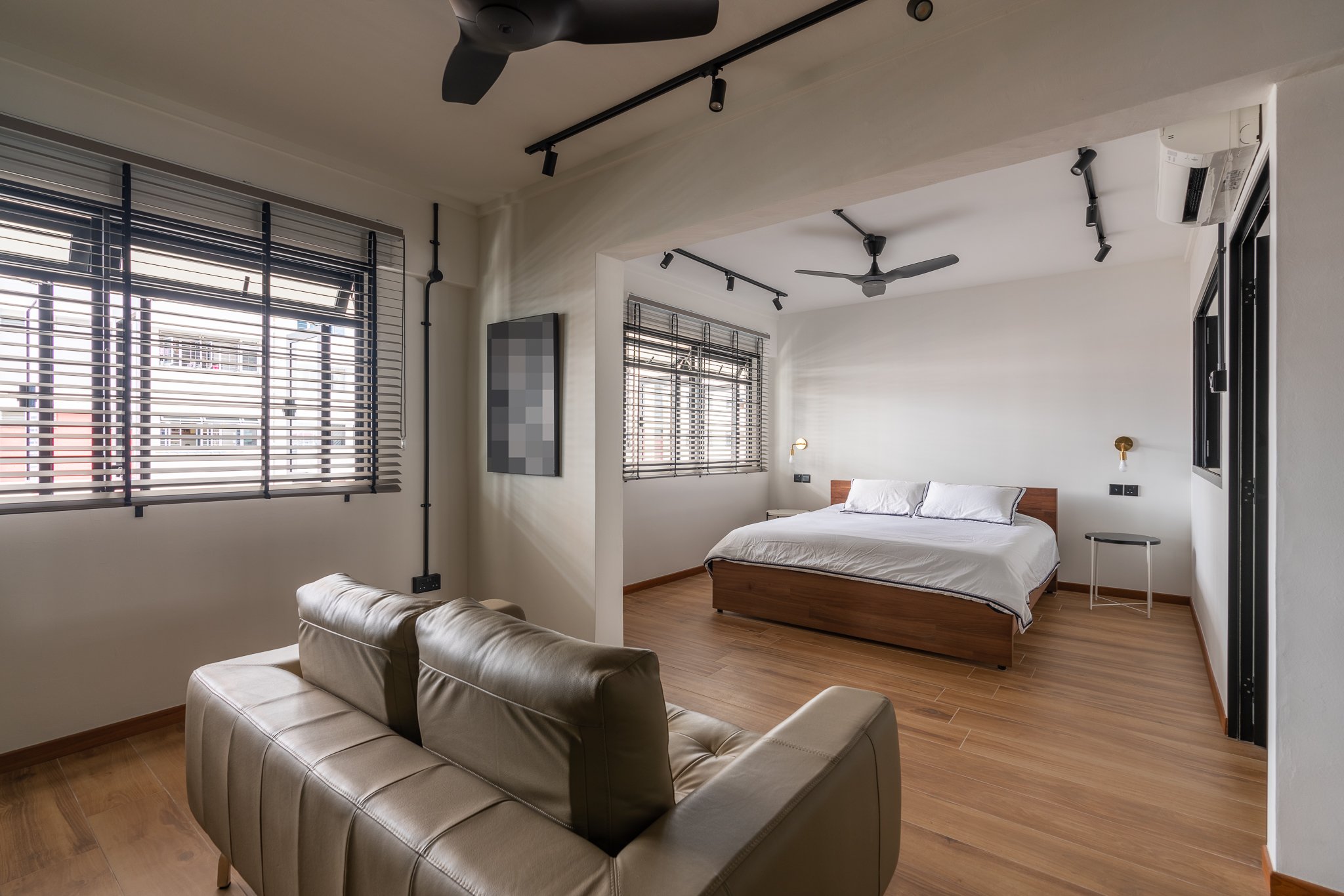 When 2 Becomes 1… Bedroom - Modern bedroom with large windows, black blinds, beige leather sofa, wooden floor, ceiling fans