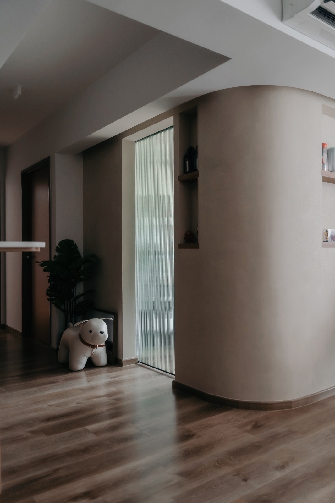 Take a peek behind our curved wall 👀 - Modern minimalist interior, cozy room, wooden flooring, soft natural light, curved