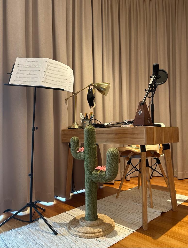 Calming bedroom vibes for Gen Z - Musical sheet music on stand, desk with desk lamp, cactus decoration, wooden desk, chair