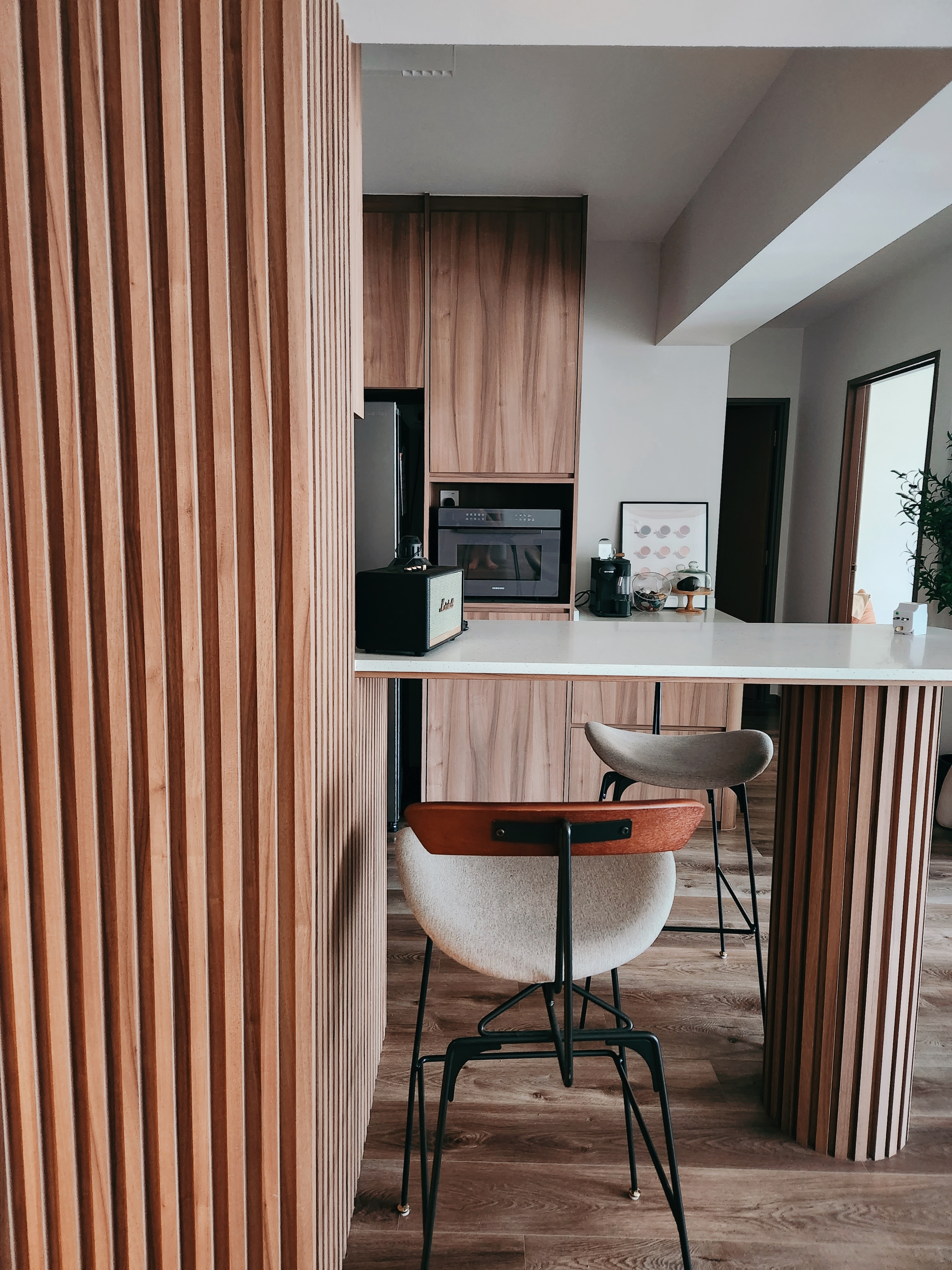 Who knew Fluted Panels can be so expensive?  - Wooden kitchen cabinetry, modern bar counter, sleek appliances, minimalist