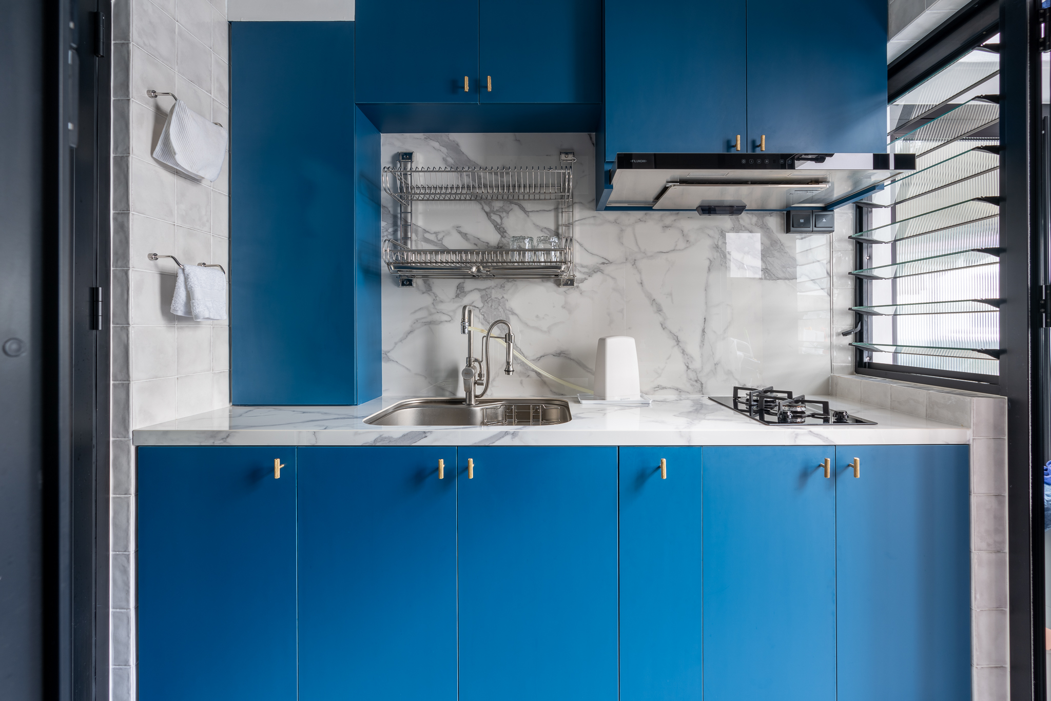 Compartmentalising Our Kitchen Space - Modern kitchen with blue cabinets, white marble countertop, stainless steel sink, gas