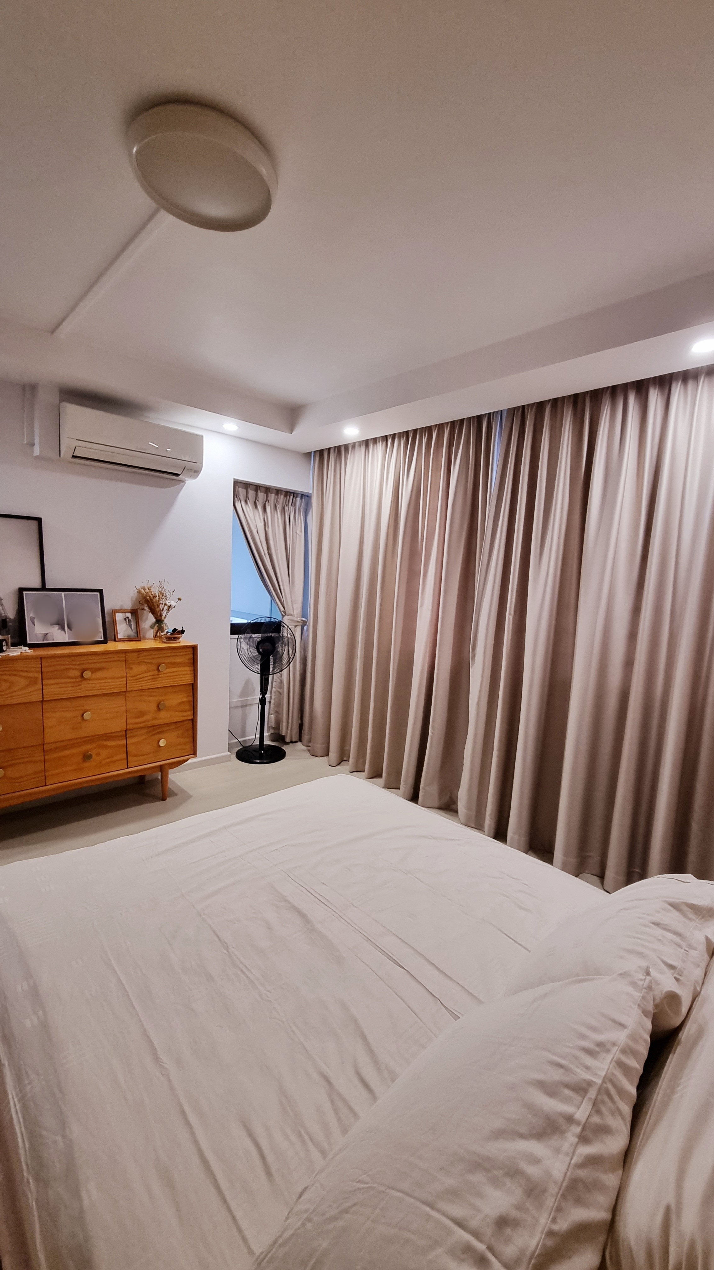 Our mix and match MASTERBEDROOM - Modern bedroom with large bed, beige curtains, wooden dresser, air conditioning unit, floor