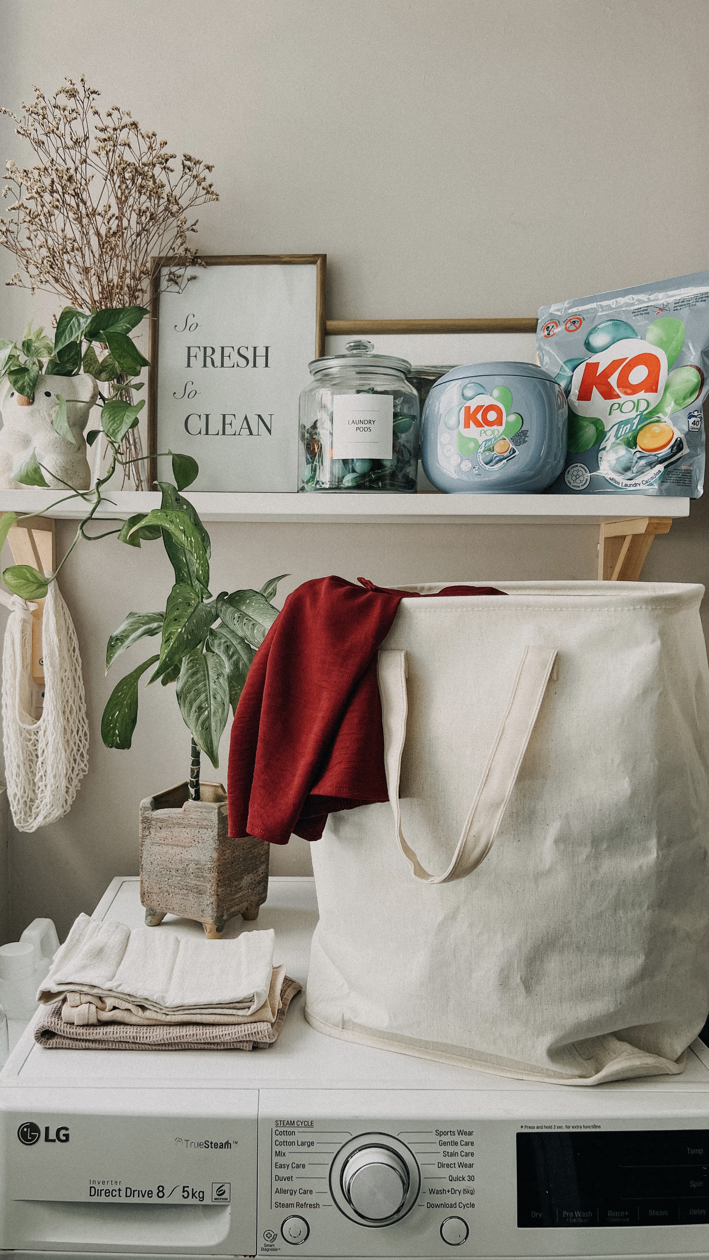 Make the most of your service yard - Organized laundry basket, white LG washing machine, folded towels, red fabric, white