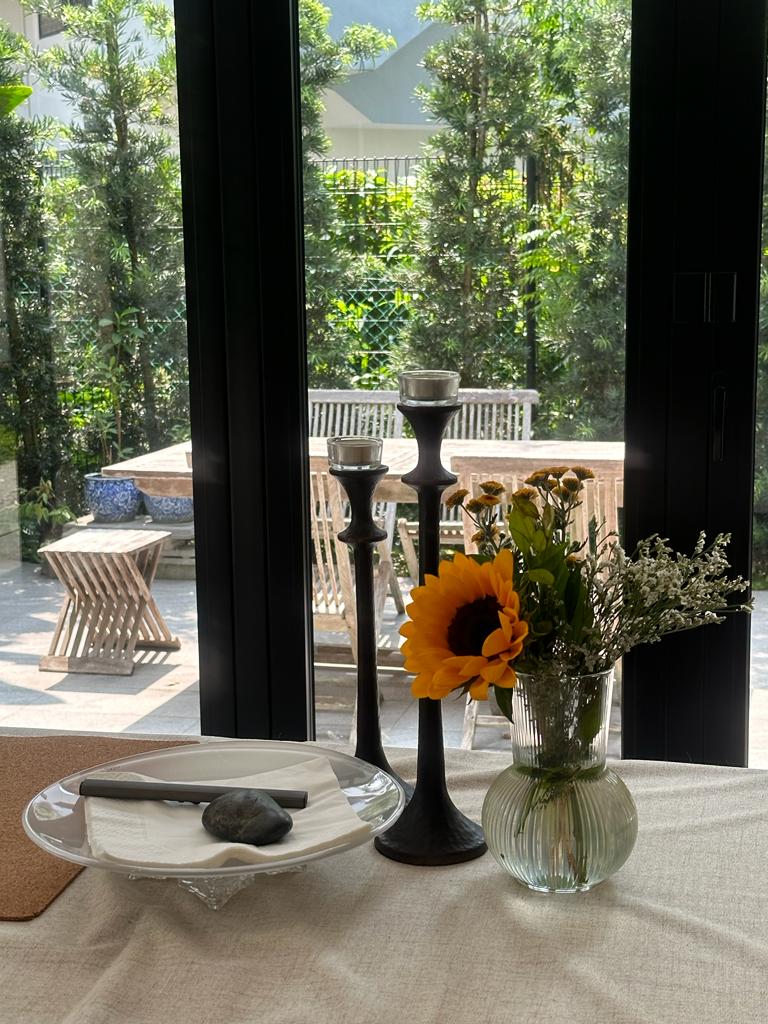 Indoor dining room with an outdoor feel - Sunflower, vase, glass, flowers, greenery, outdoor, patio, table, candles, black