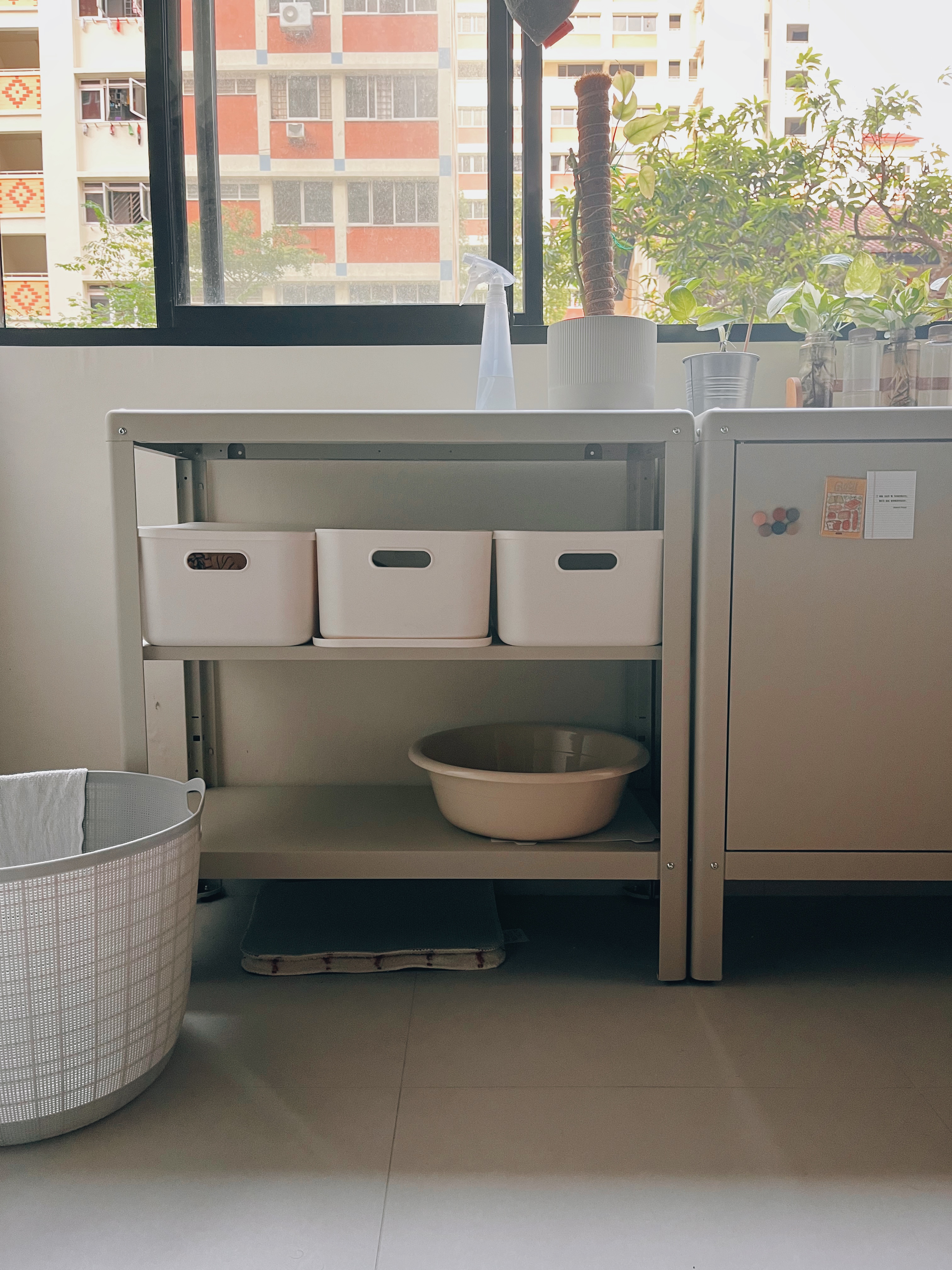 Optimising vertical space in this simple service yard - window sill, laundry basket, white laundry basket, beige basin